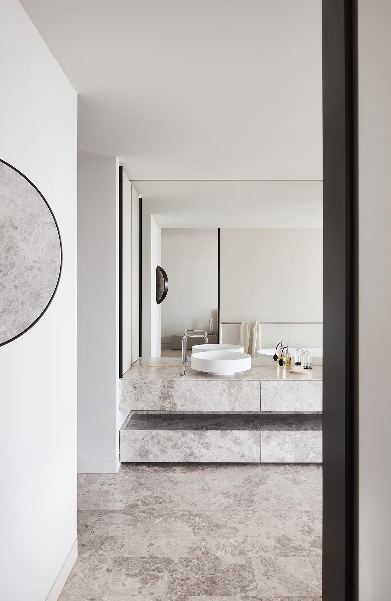 A modern bathroom with limestone vanity and floors.