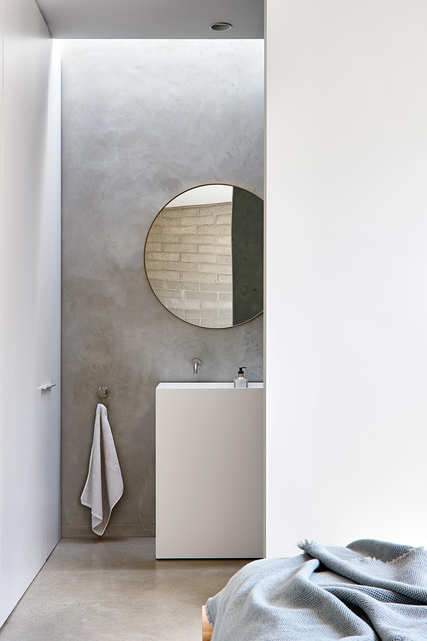 Modern ensuite bathroom with round mirror.