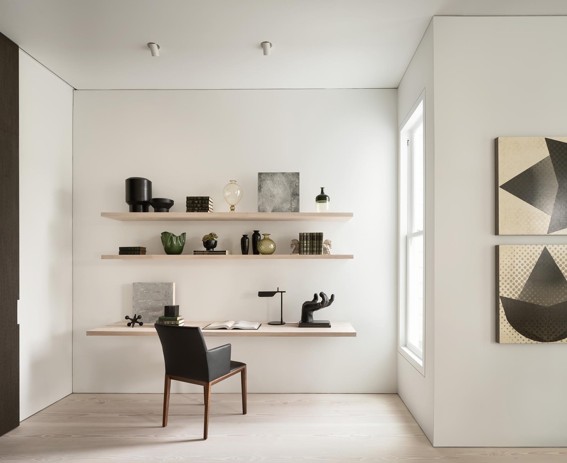 A small home office with floating wood shelves and desk.