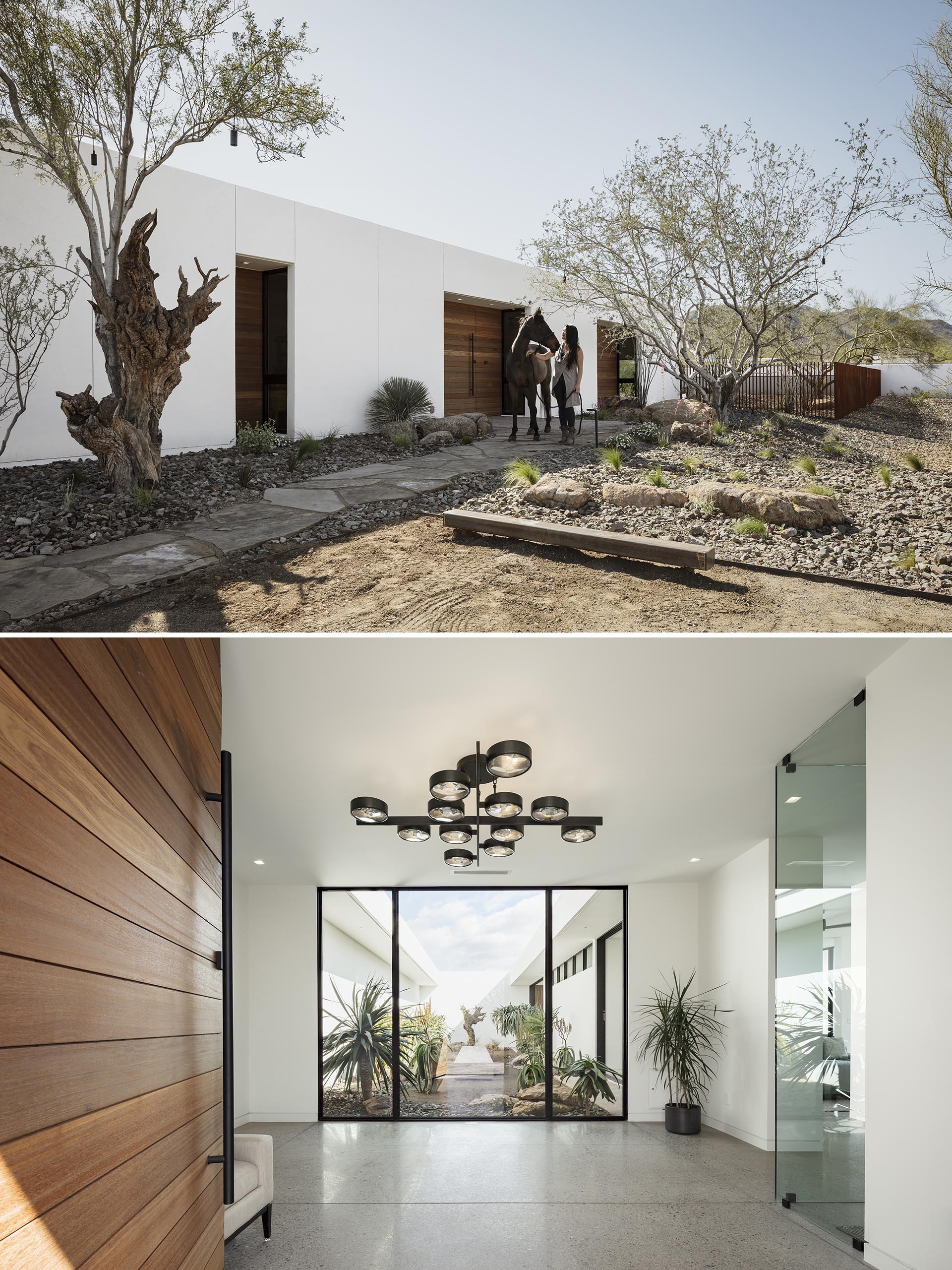 A modern white stucco house with a large wood front door that opens to a foyer with views of a courtyard.