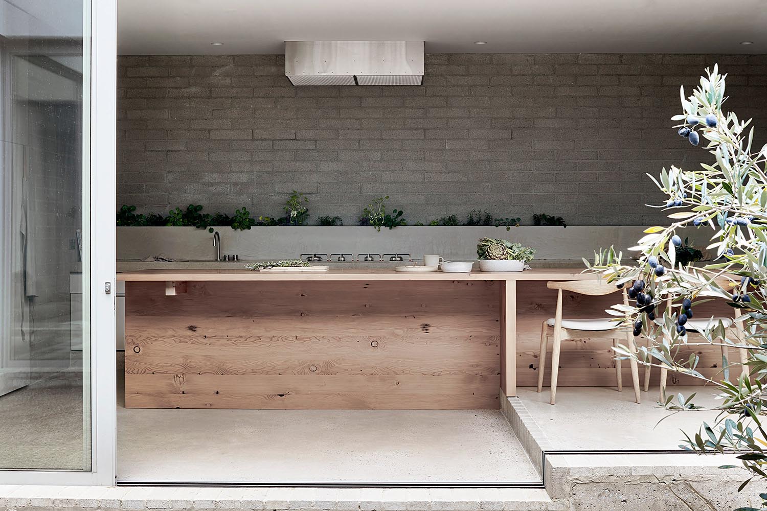 A modern kitchen with a wood island that transitions into a dining table.