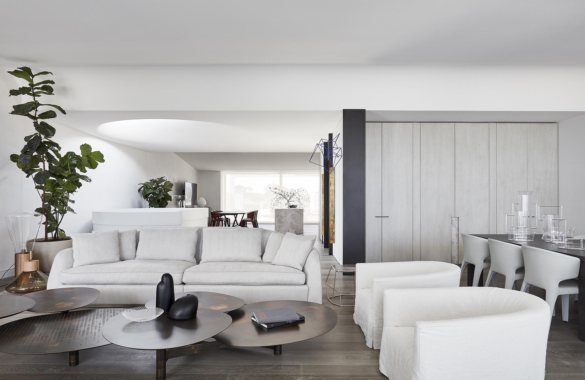 Modern living room with white sofa and armchairs.