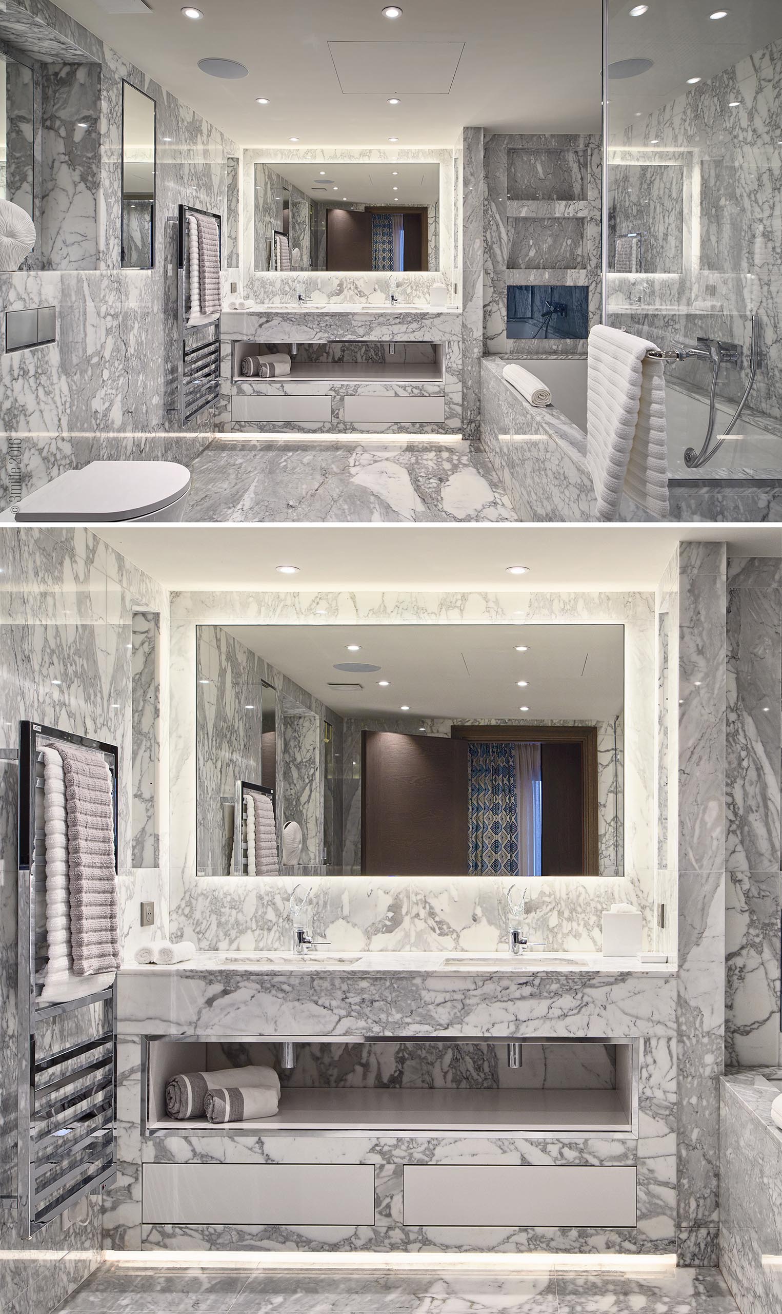 A bathroom with walls and floor covered in grey and white stone.