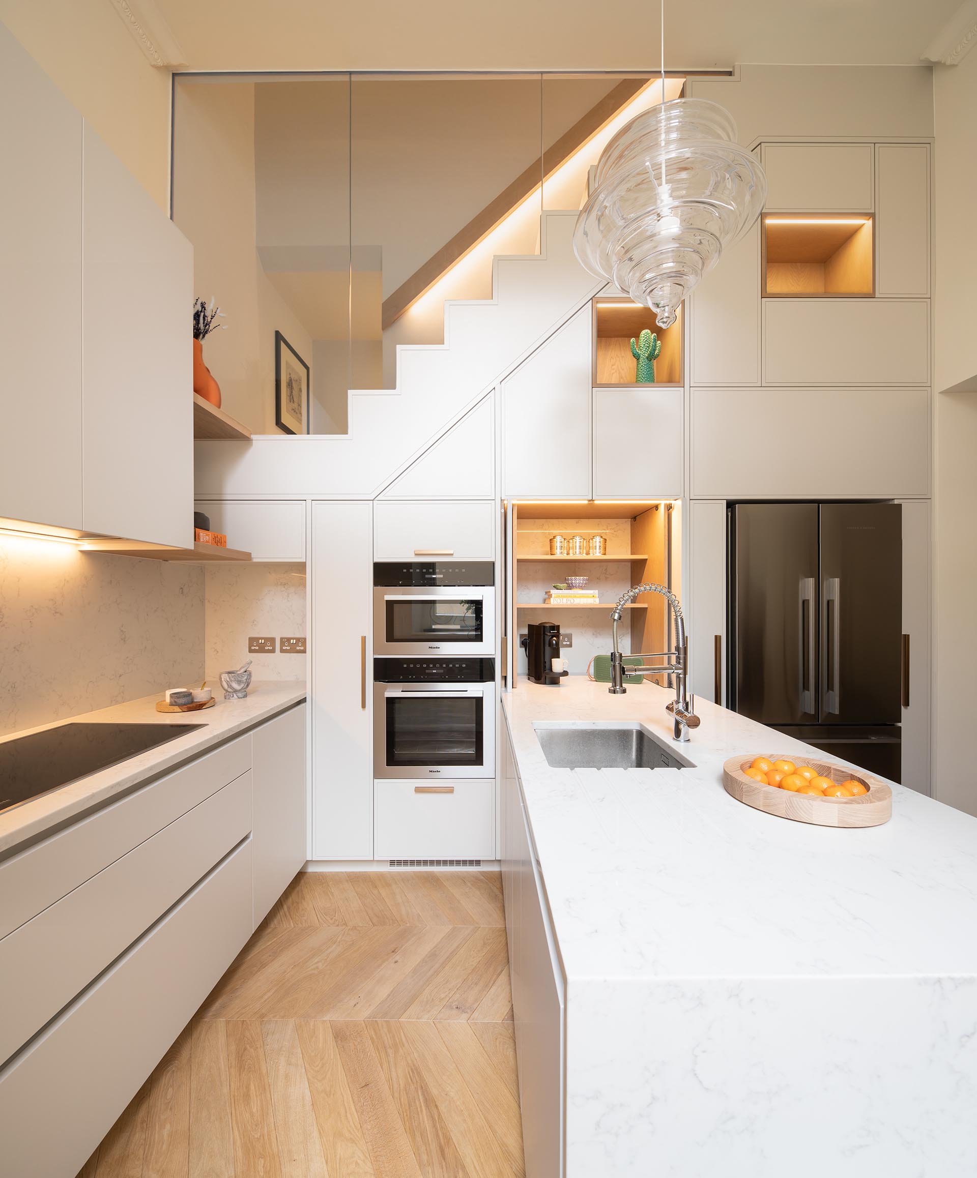 A white kitchen with recessed LED lighting.