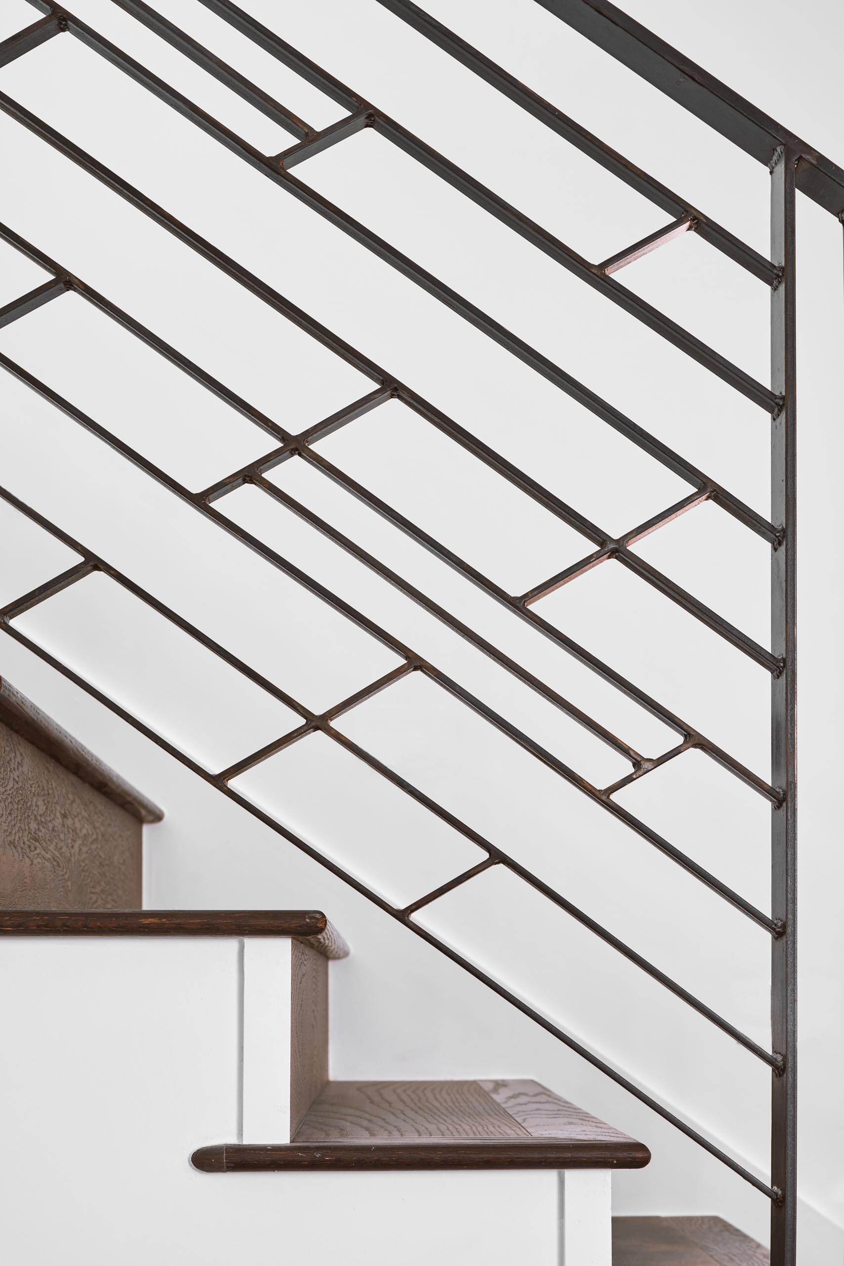 Modern stairs with wood treads and a graphic railing.