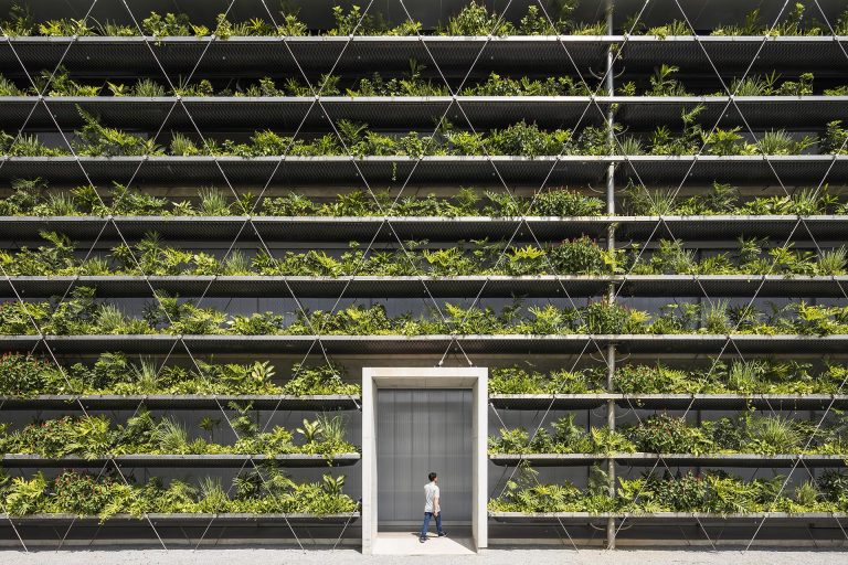 Rows Of Plants Line The Exterior Of This Factory Building