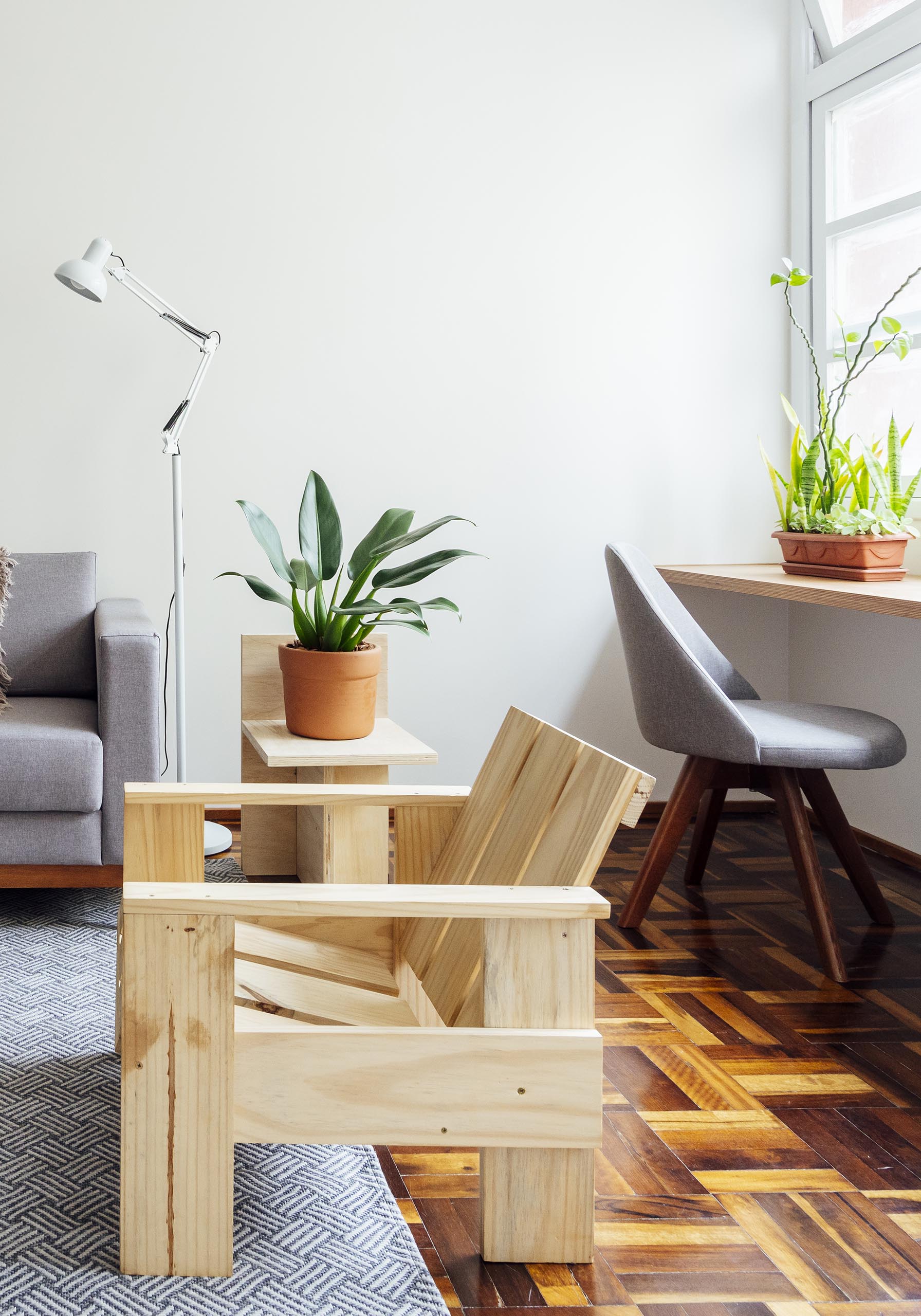 A simple wood shelf acts as a desk by the windows.