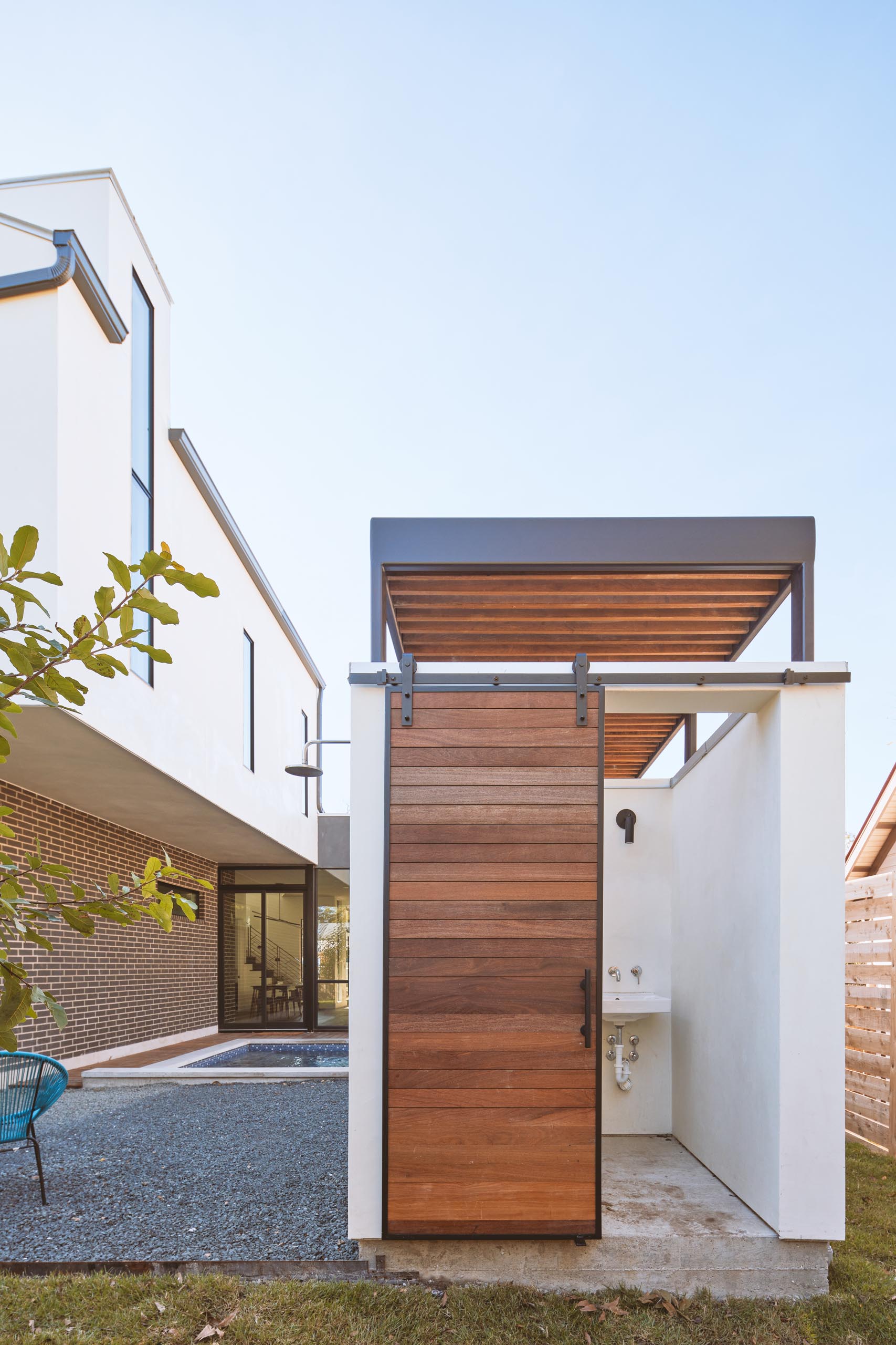 A small pool house with a bathroom and sliding door.