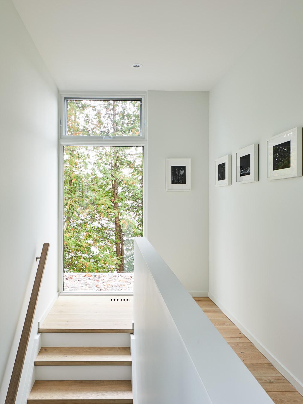 A white interior with wood stair treads and flooring.