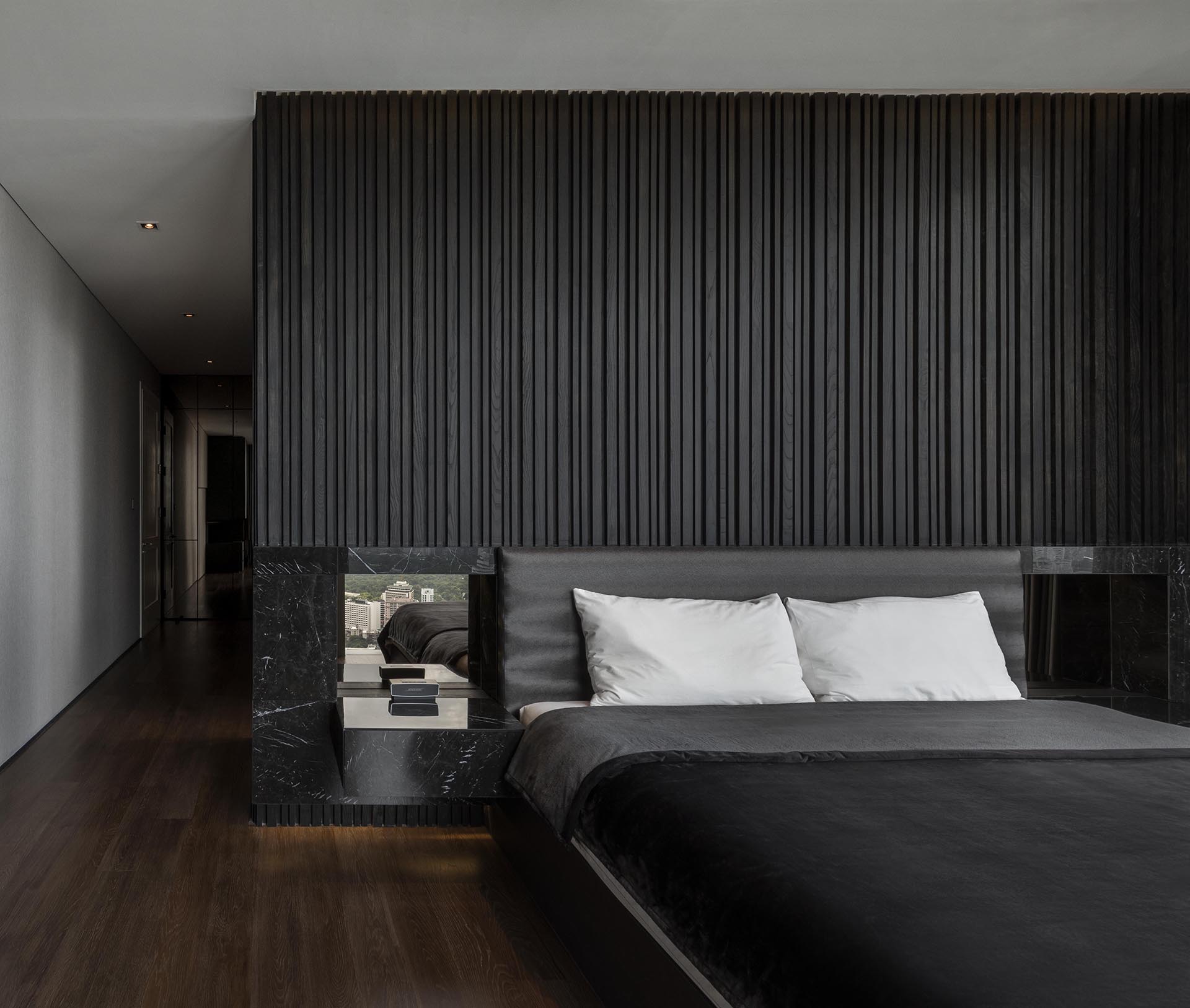 A textured black wood accent wall in a modern bedroom.