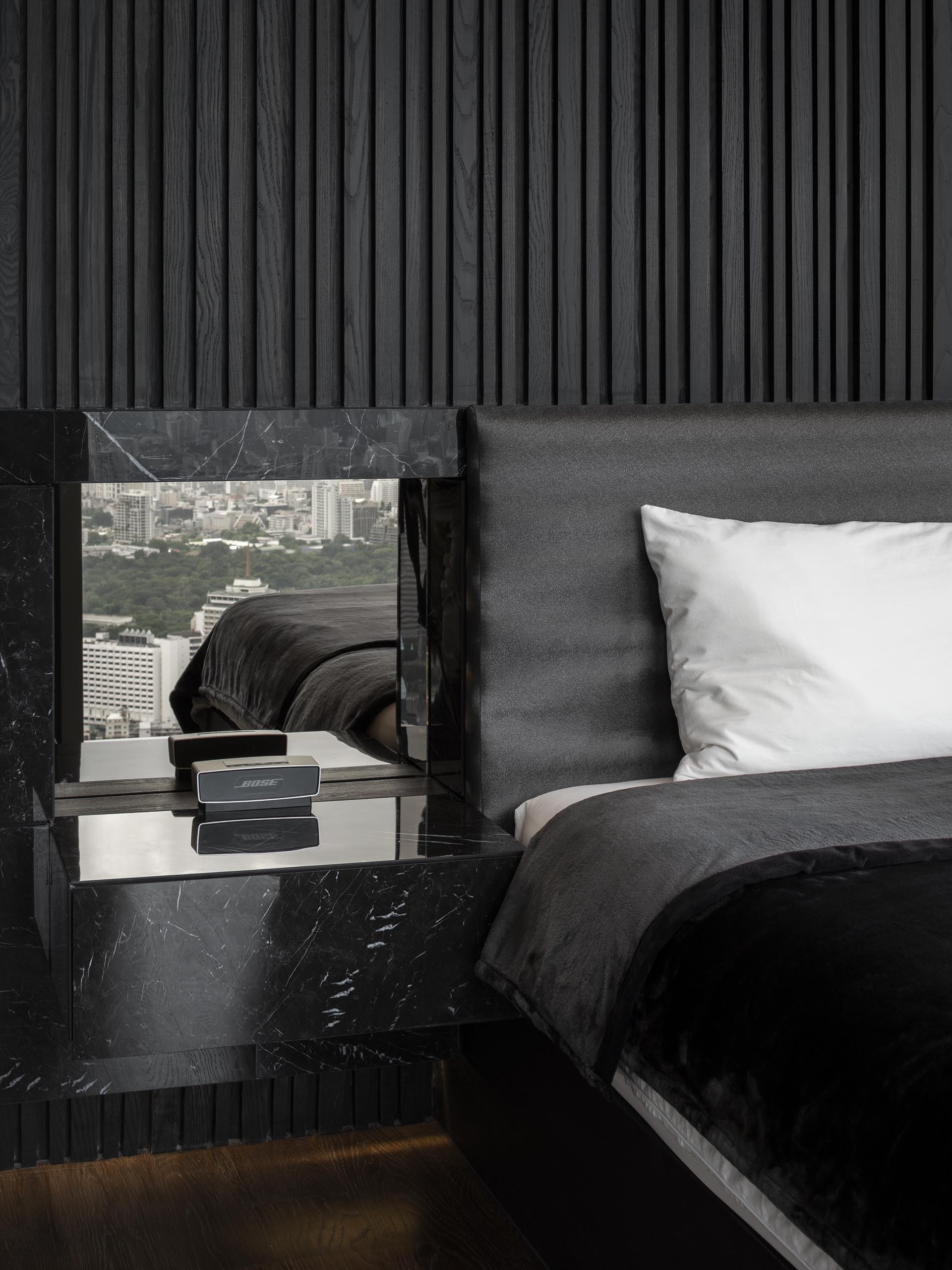 A textured black wood accent wall in a modern bedroom.