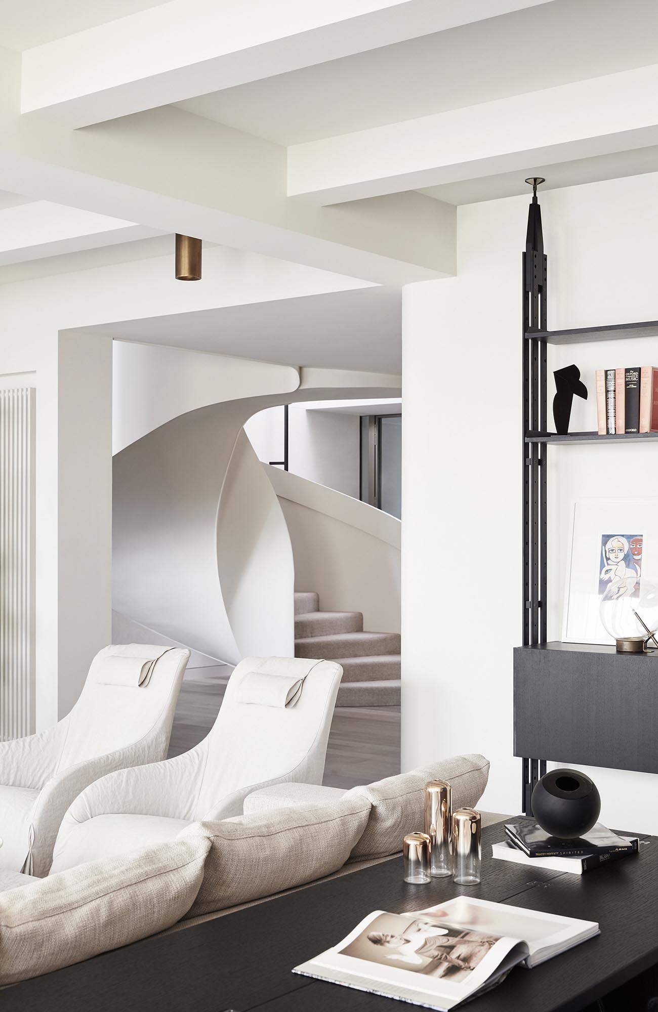 A modern interior with bright furniture and white spiral stairs.