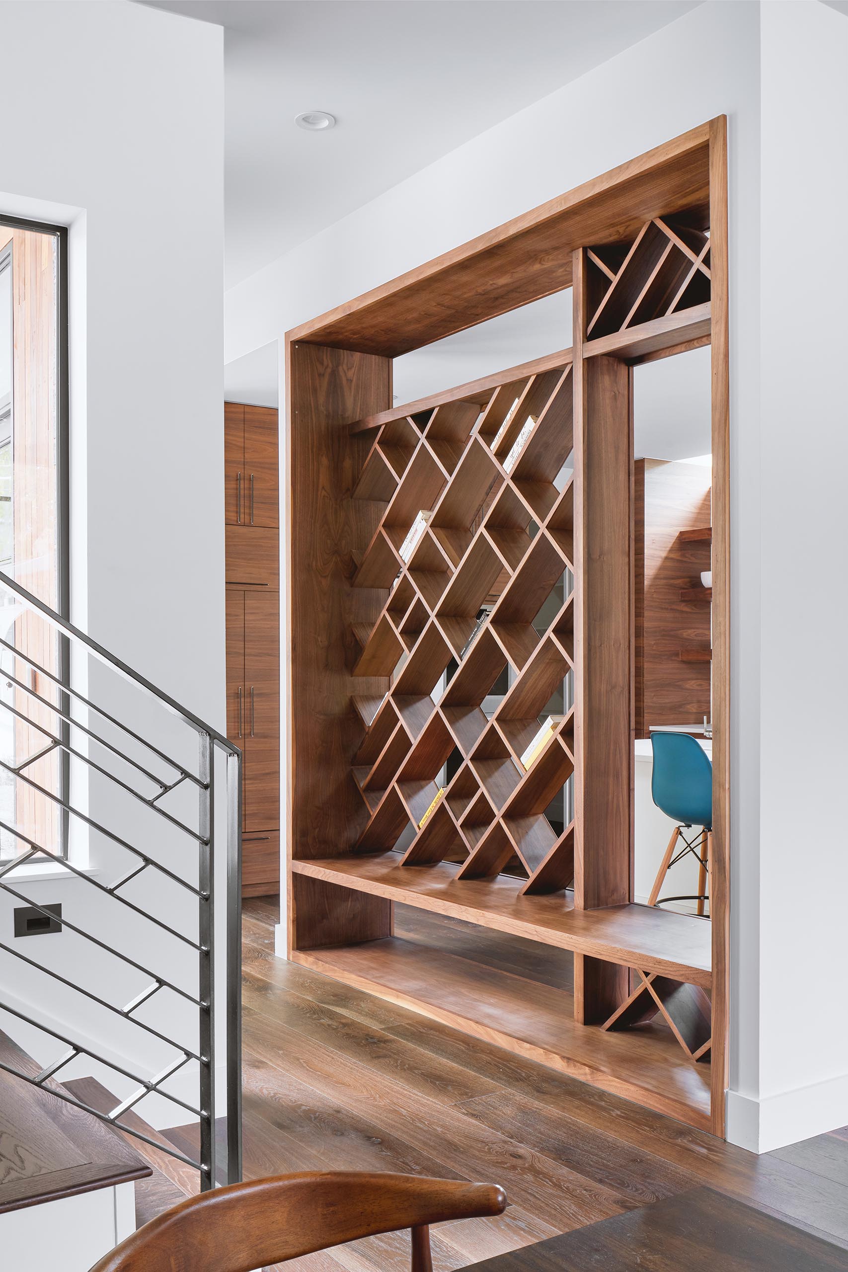 A custom entryway bench that has see-through diagonal wood shelving above.