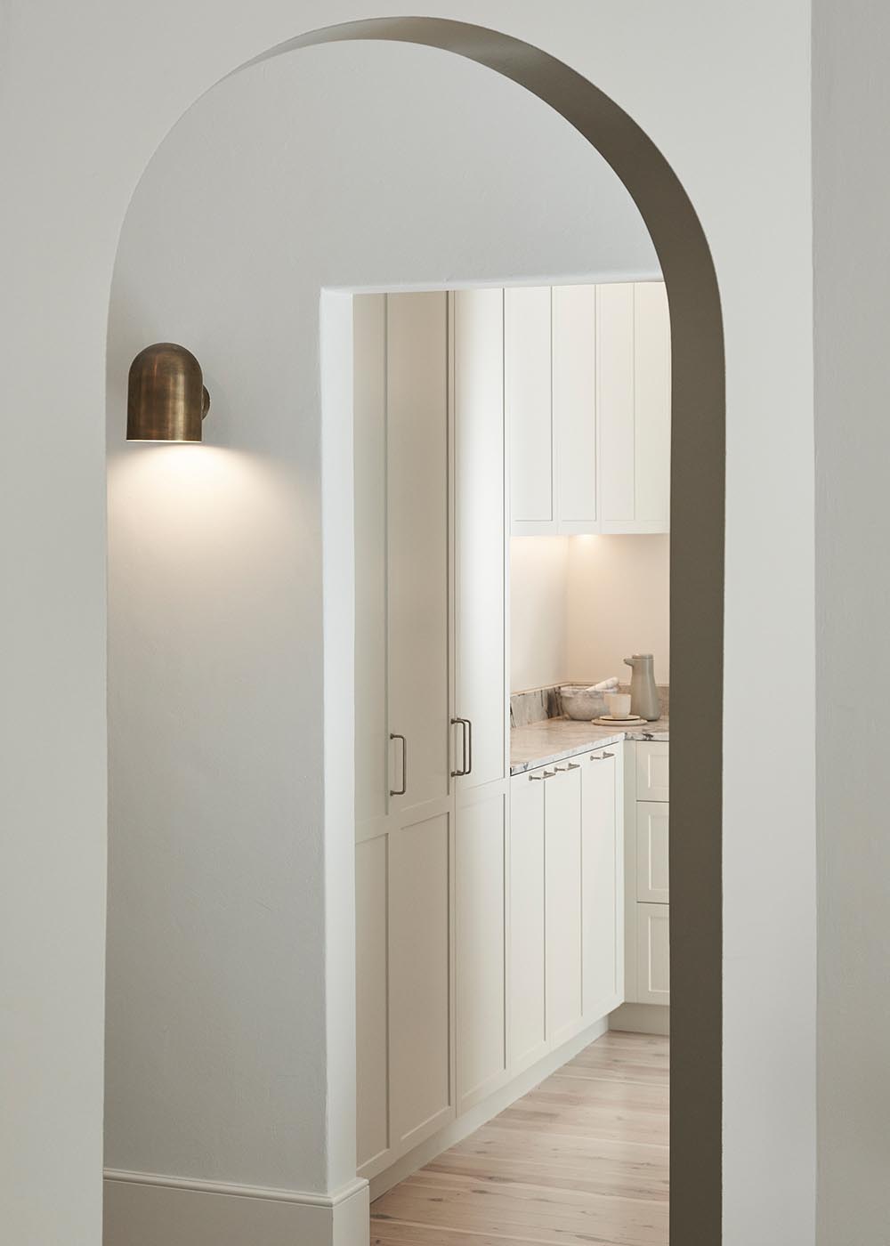 An emphasized curved arch and feature lighting are a subtle nod to Art Deco design elements.