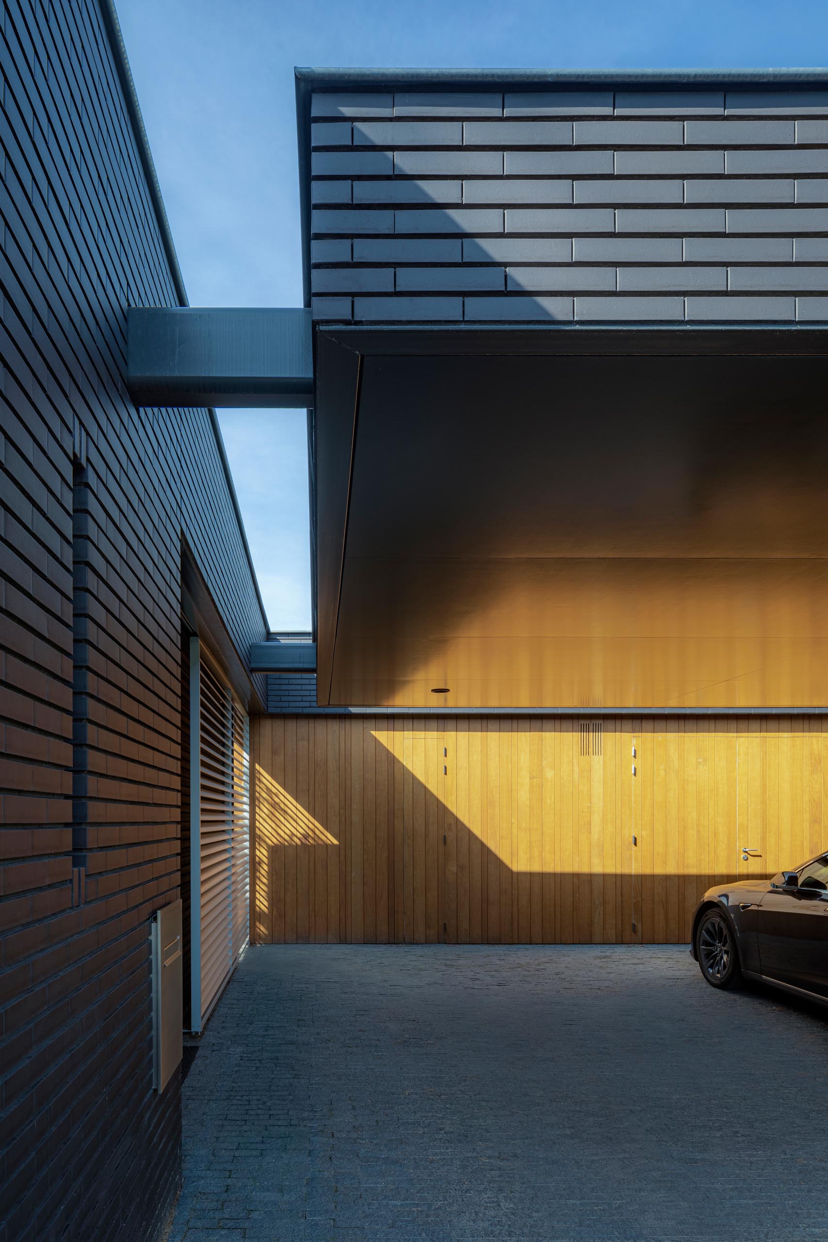 A modern black brick house with wood accents.