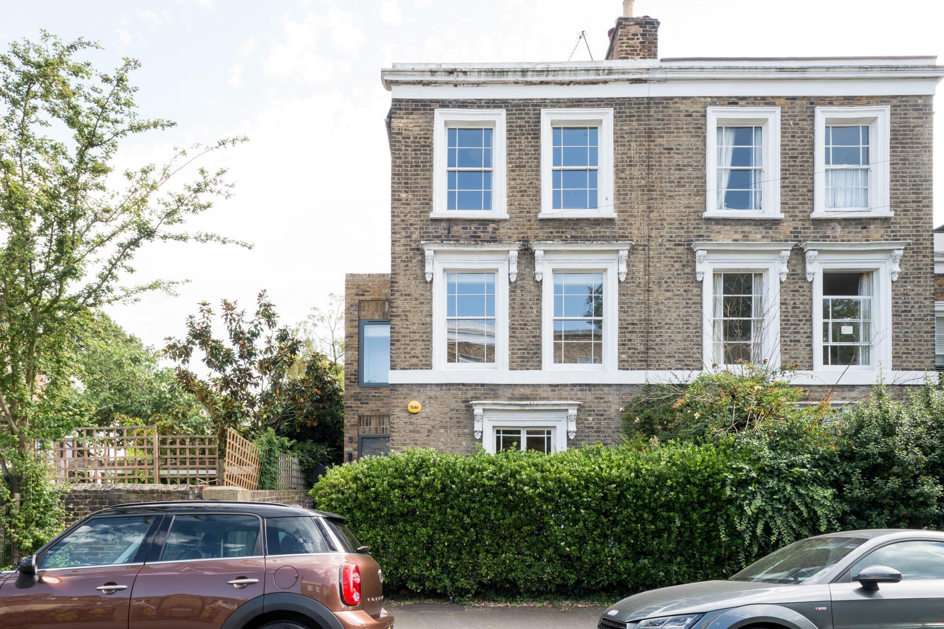 A brick home with white window frames.