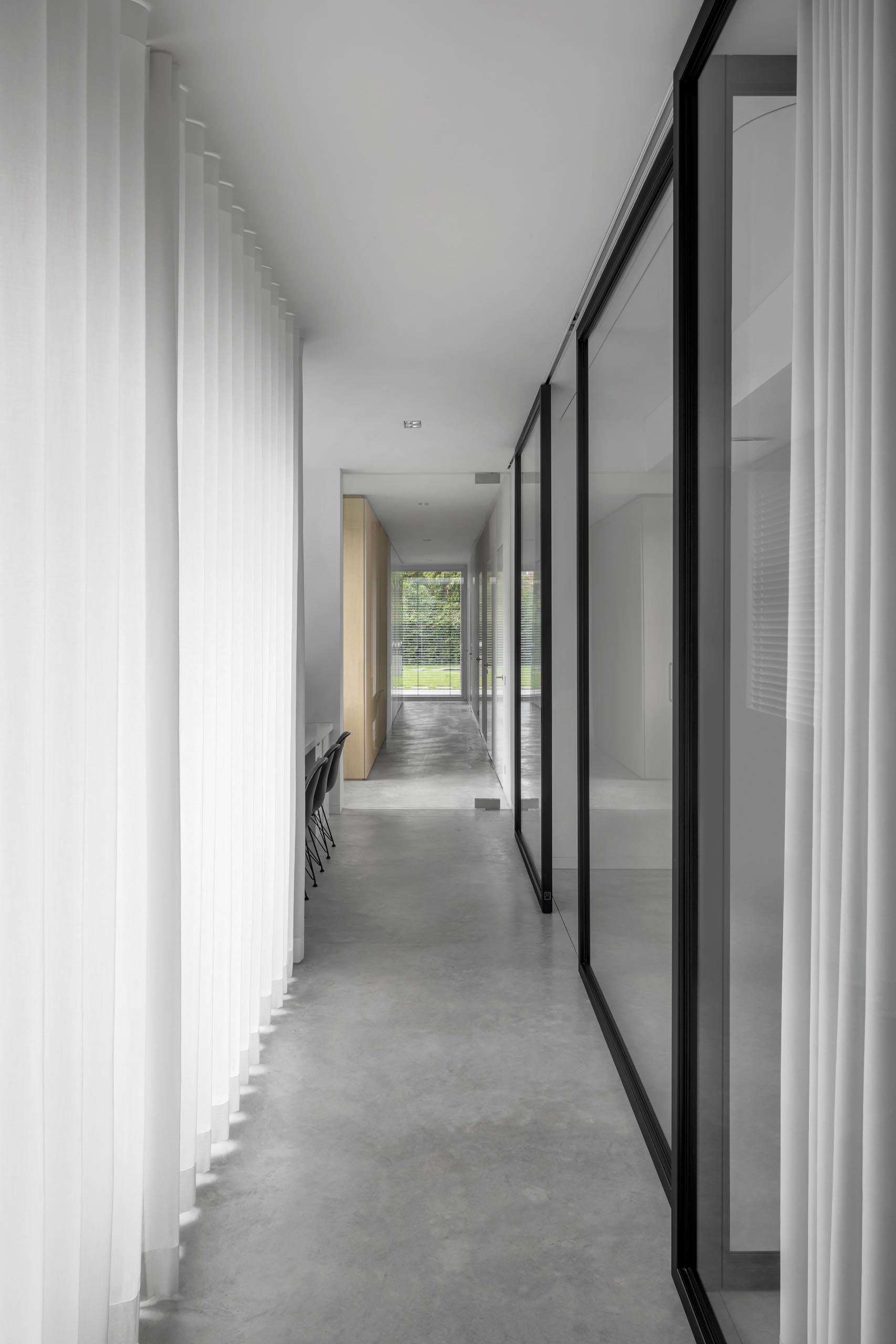 A white and black hallway with concrete floors.