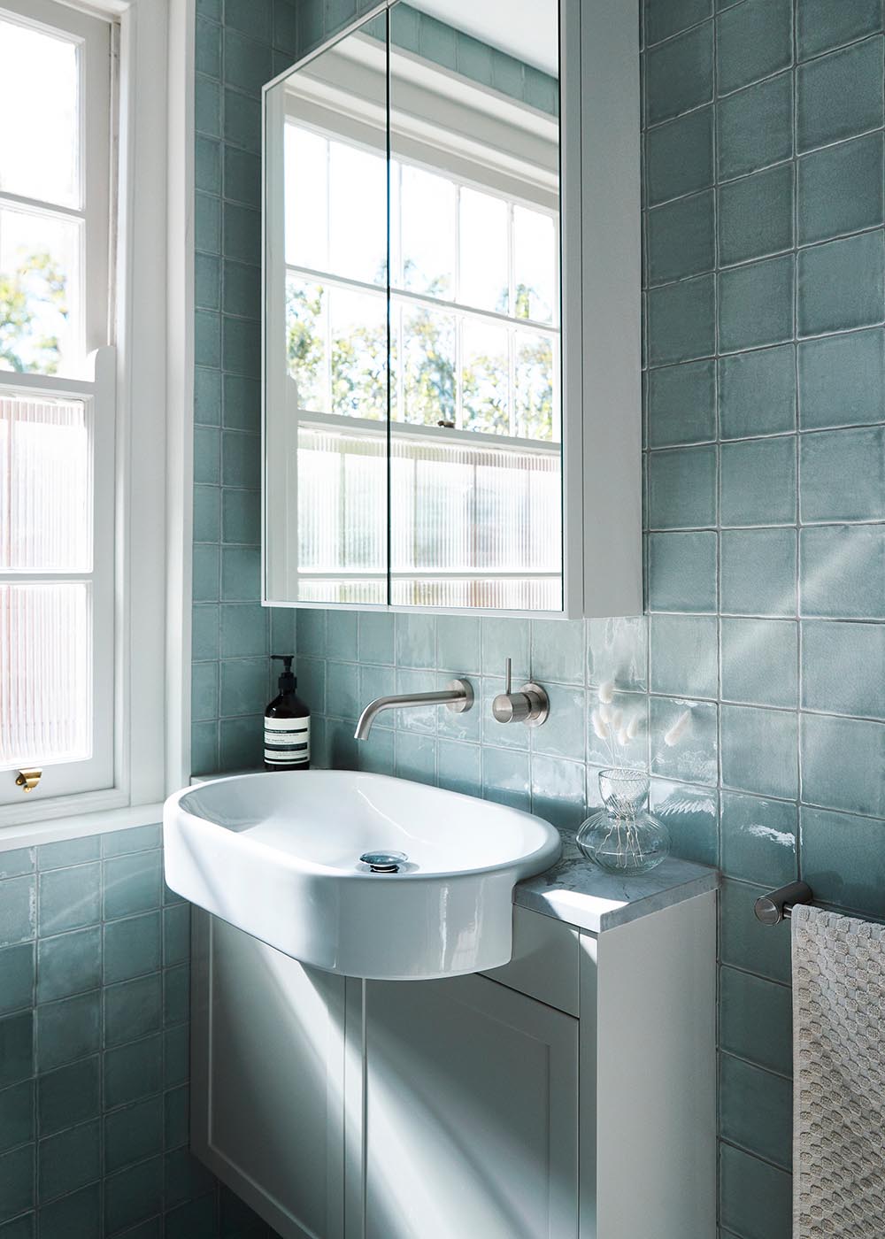 Soft blue handmade tiles employed in the bathroom offer a sense of restrained luxury.