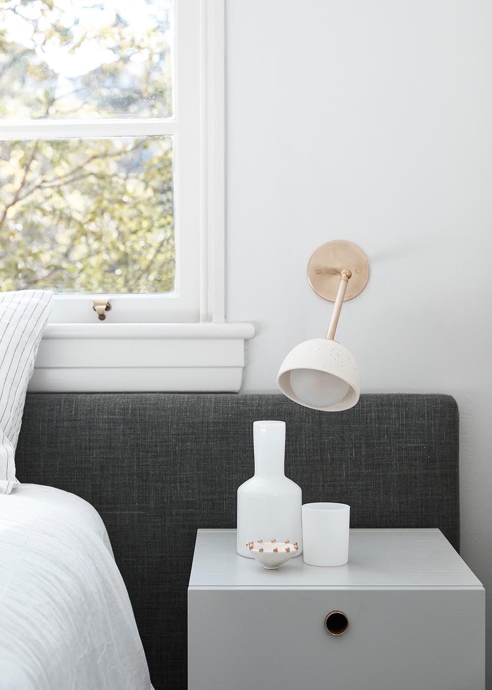 In this modern bedroom, a simple upholstered gray headboard is the only dark element that can be found.