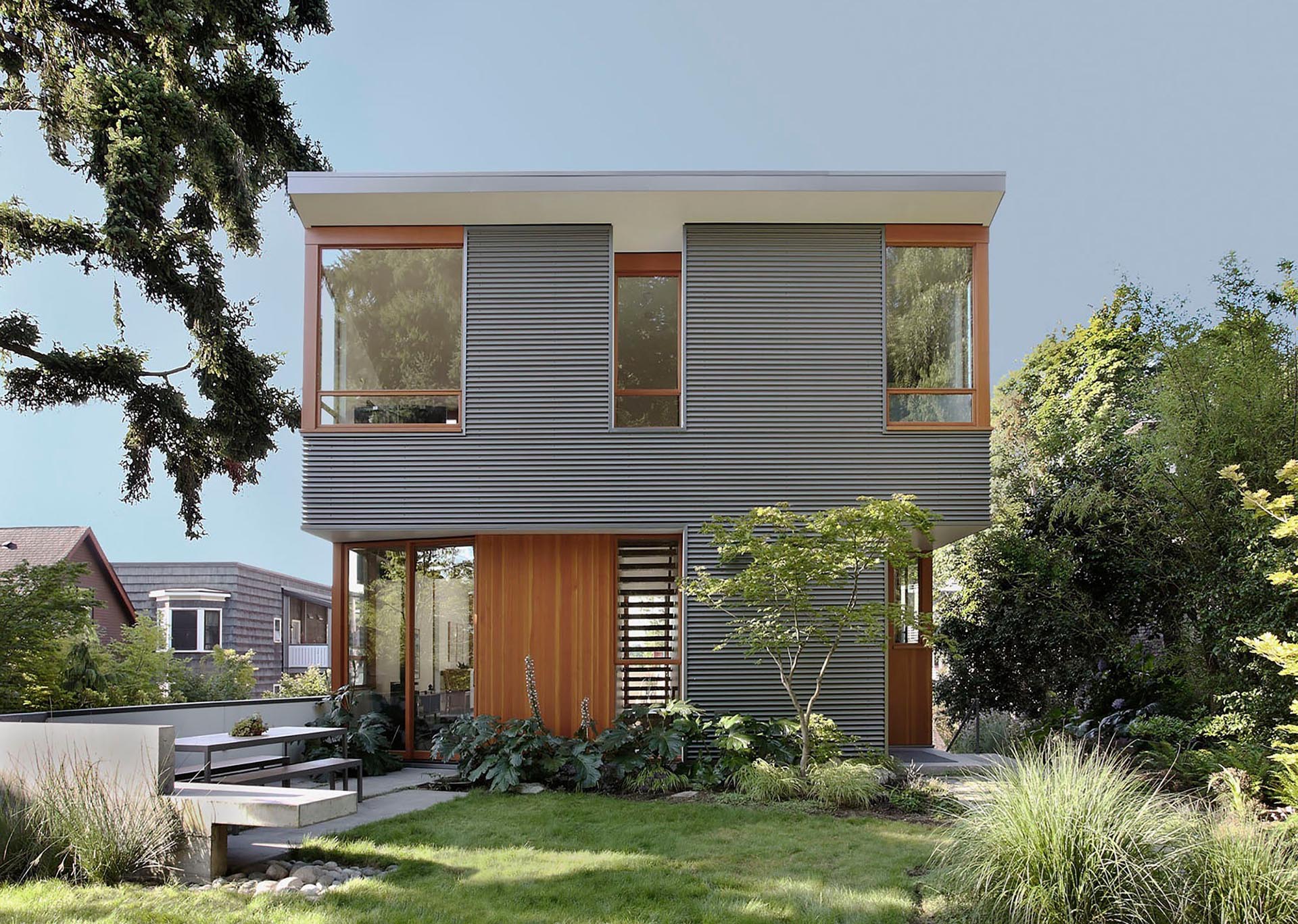 A modern house with corrugated metal siding and wood window frames.