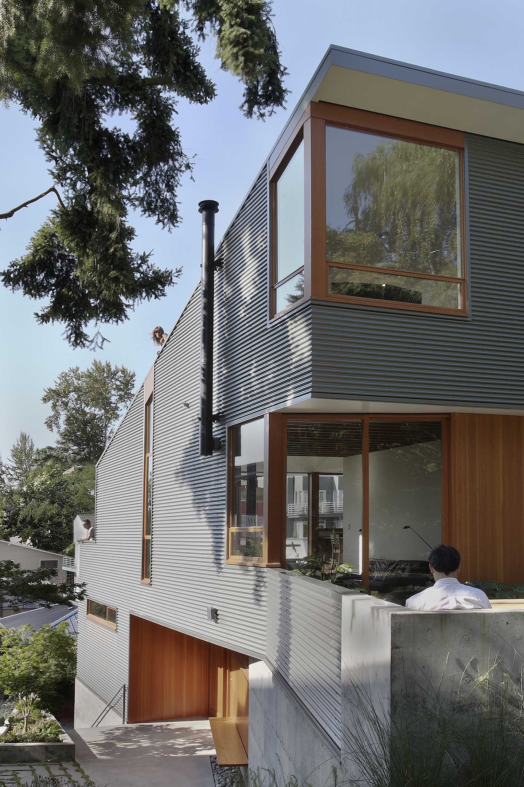 A house with corrugated metal siding and wood window frames.