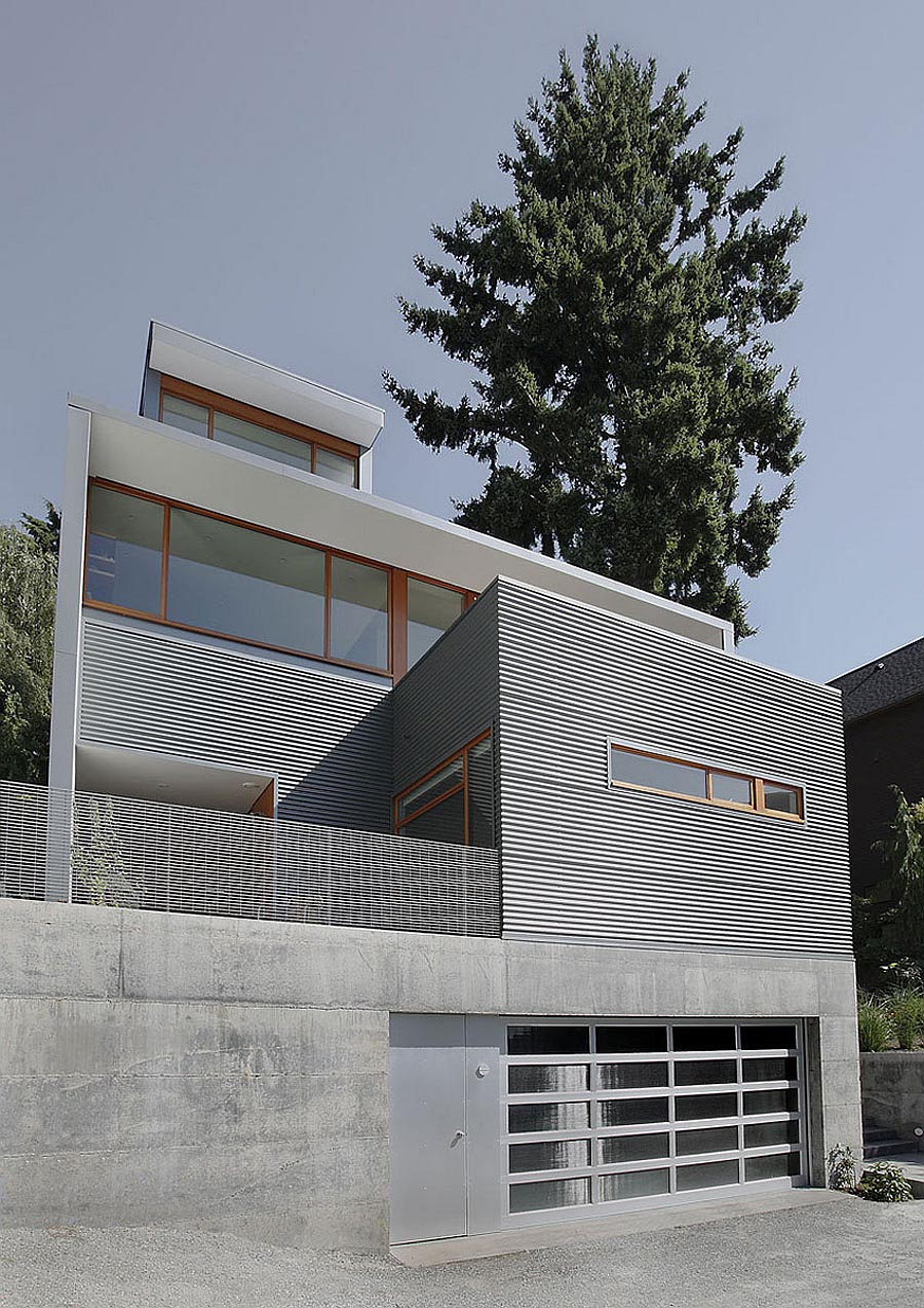 A modern house with corrugated metal siding, concrete foundation, and wood window frames.