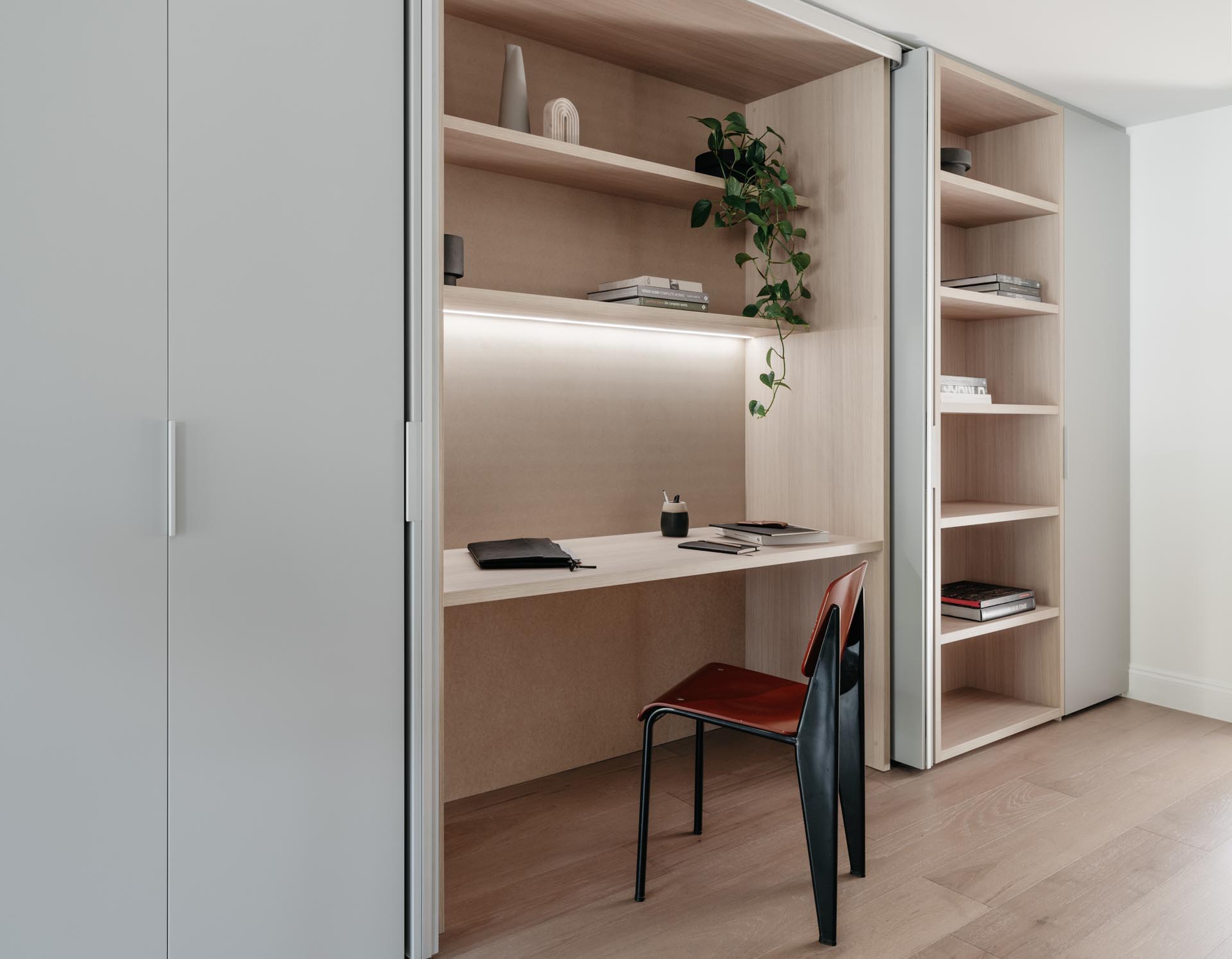 A modern wood-lined home office hidden within a closet.