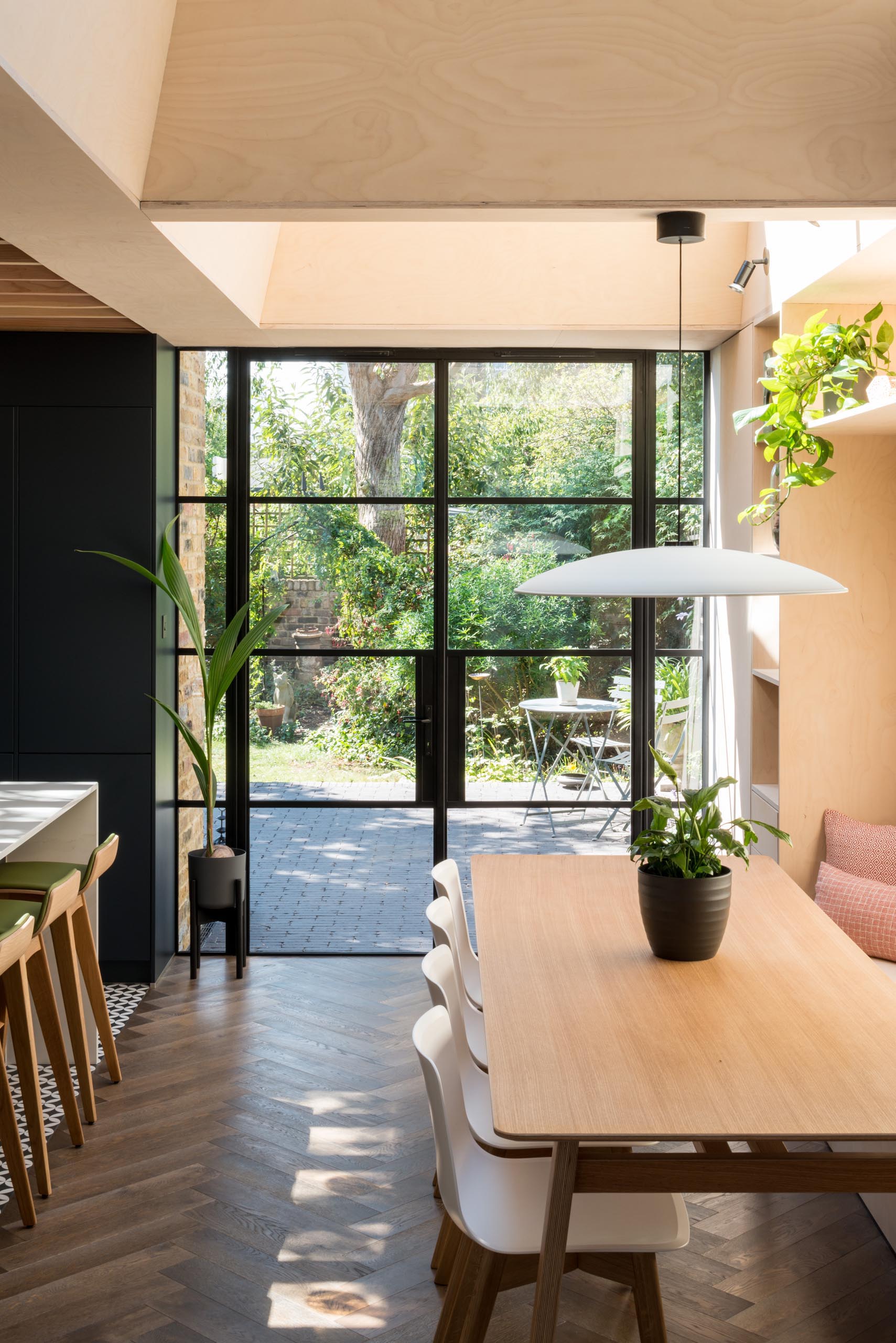 Black framed glass doors (Crittall doors) open to the garden.