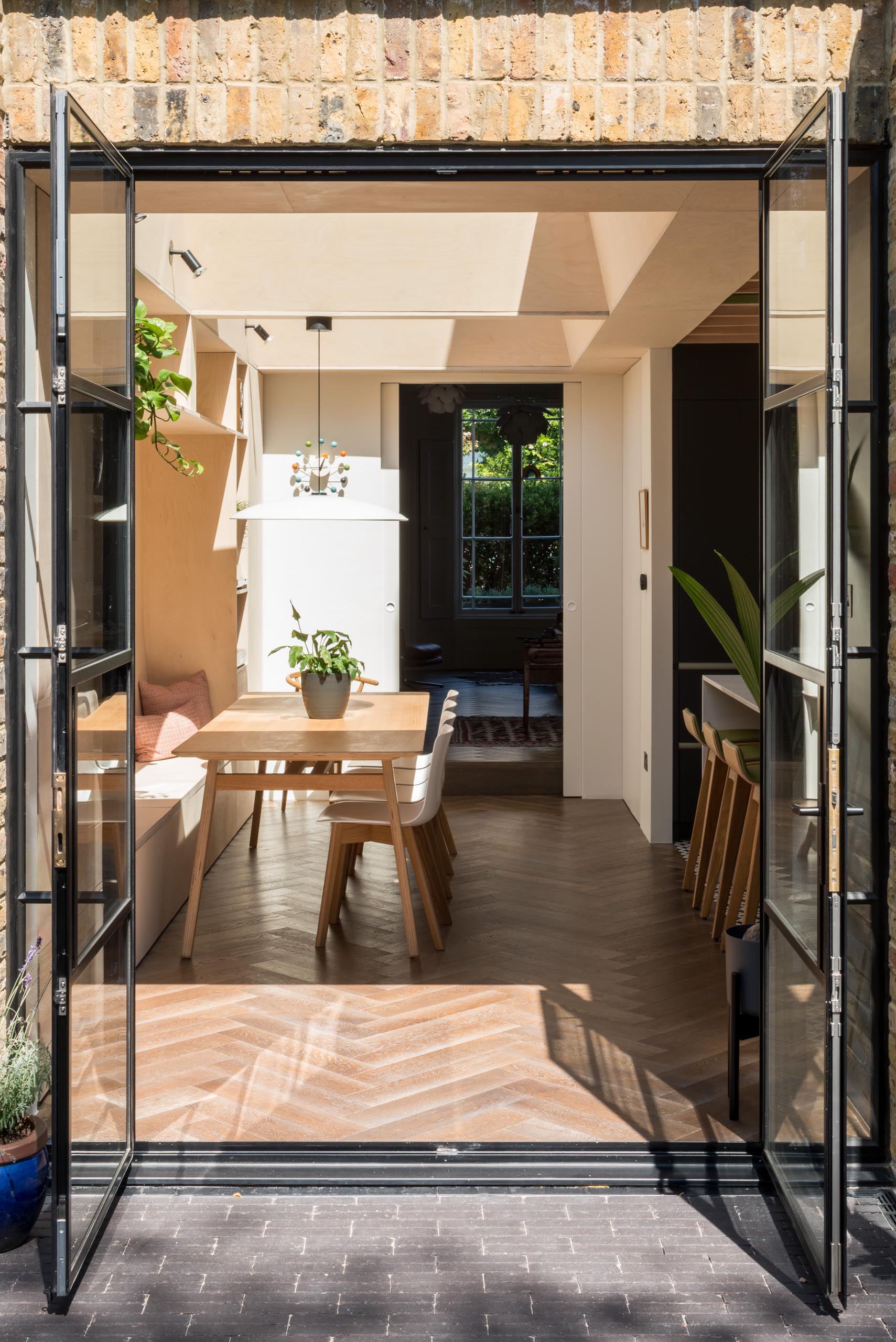 Black framed glass doors (Crittall doors) open to the garden.