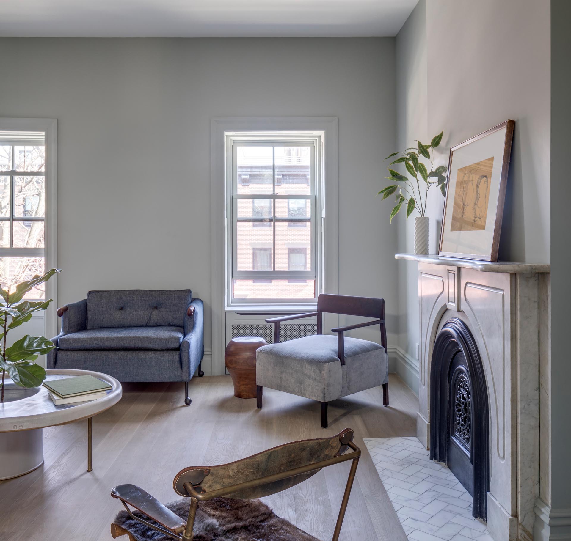 A sitting room with an arched fireplace that includes a tiled hearth.