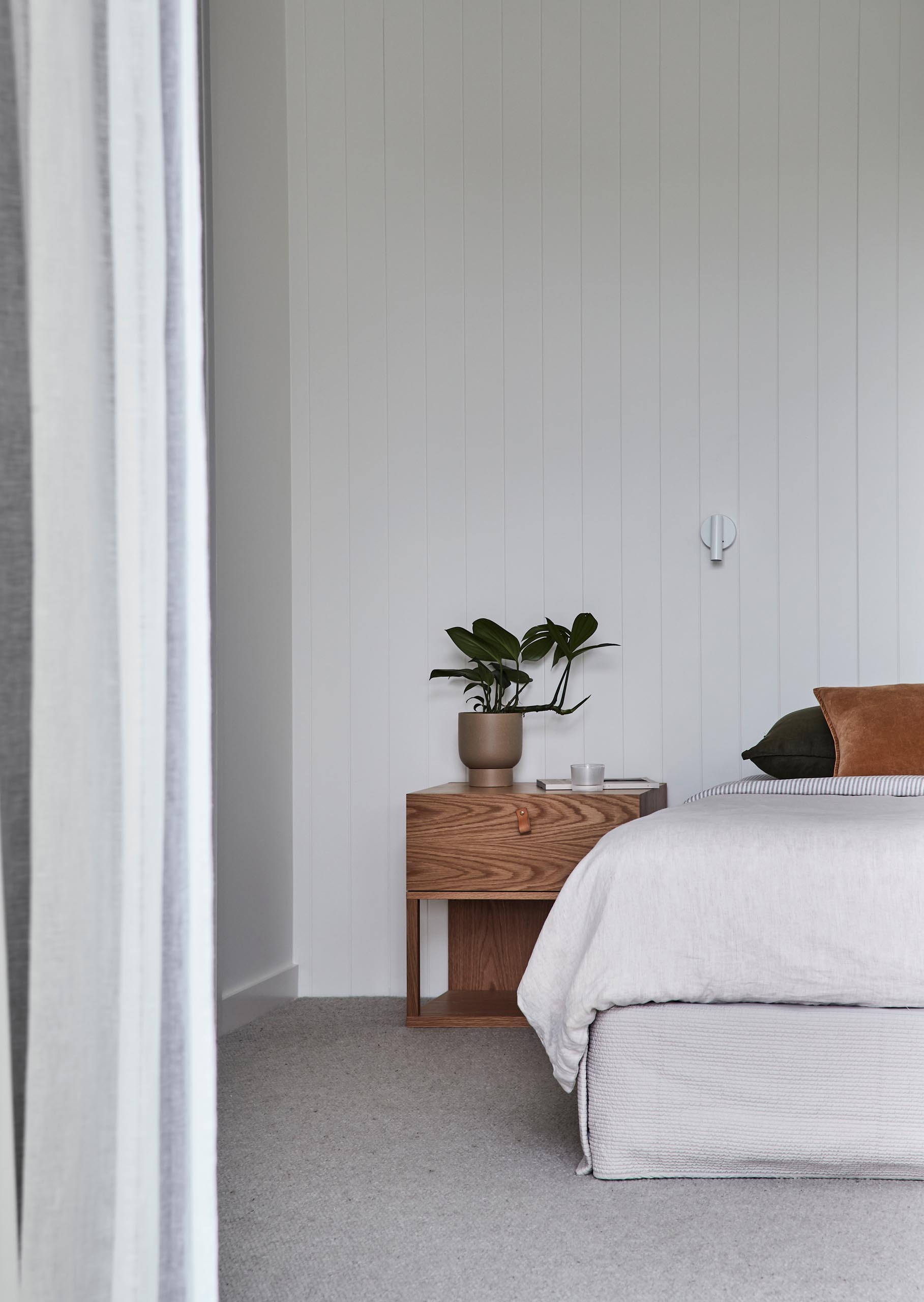 In this modern bedroom, the design has been kept minimal, while the wood and leather accents reference the other areas of the home.