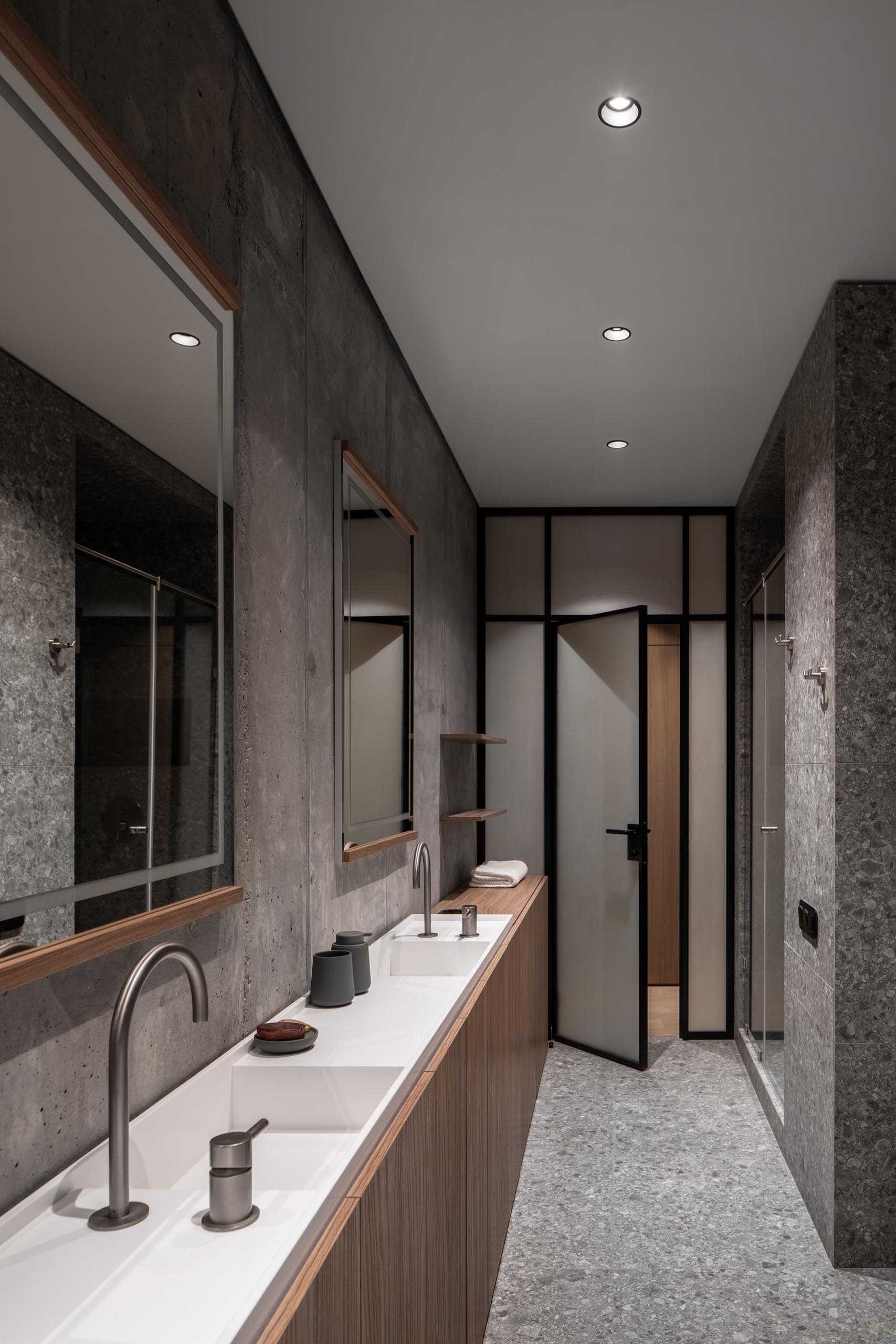 A modern bathroom with a custom-made narrow double sink vanity with white countertop and wood cabinets underneath