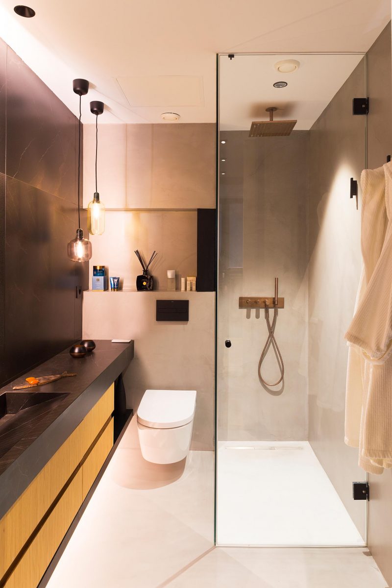 A modern bathroom with a black and wood vanity, a glass enclosed shower, and a shelving nice.