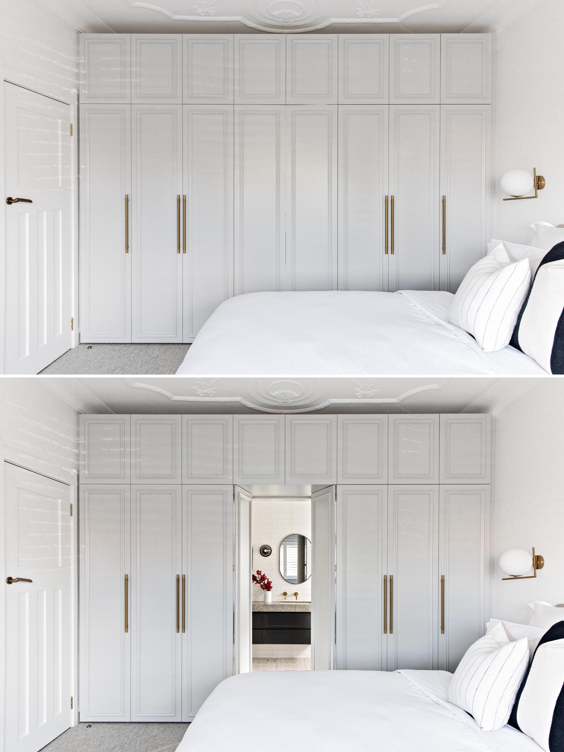 In this contemporary bedroom, light grey closets hide the entry to the bathroom.