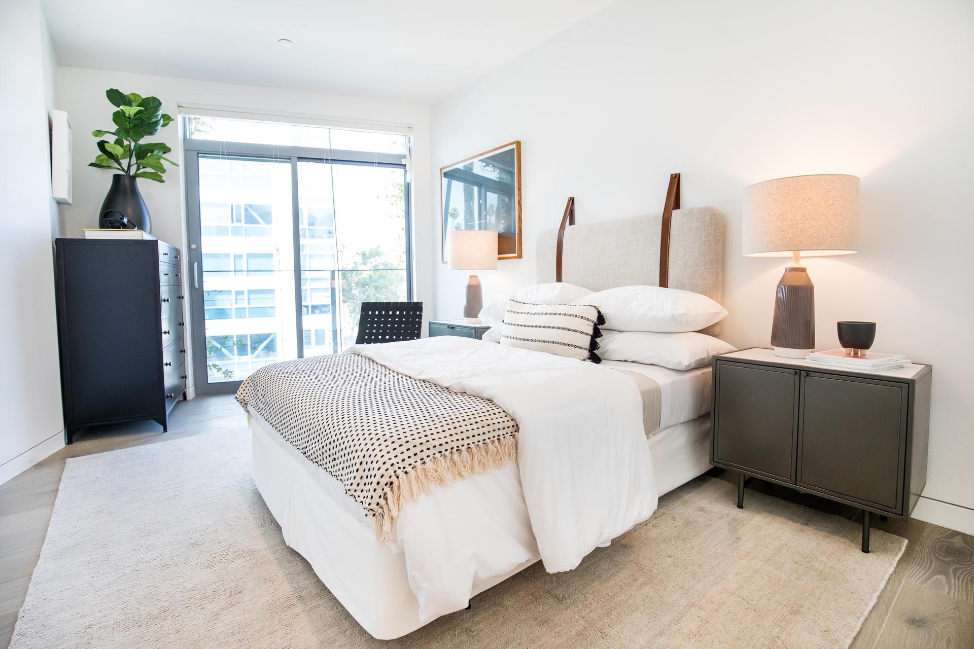 A modern bedroom with a wall mounted headboard.