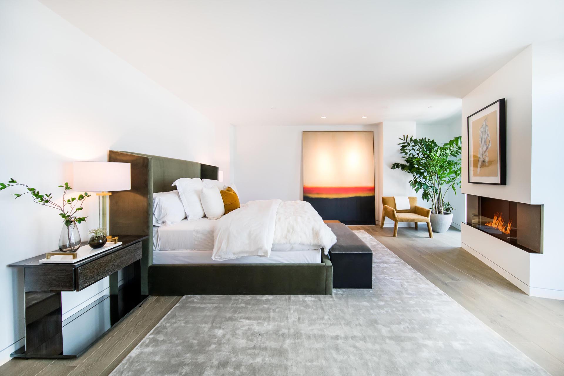 A modern bedroom with a fireplace.