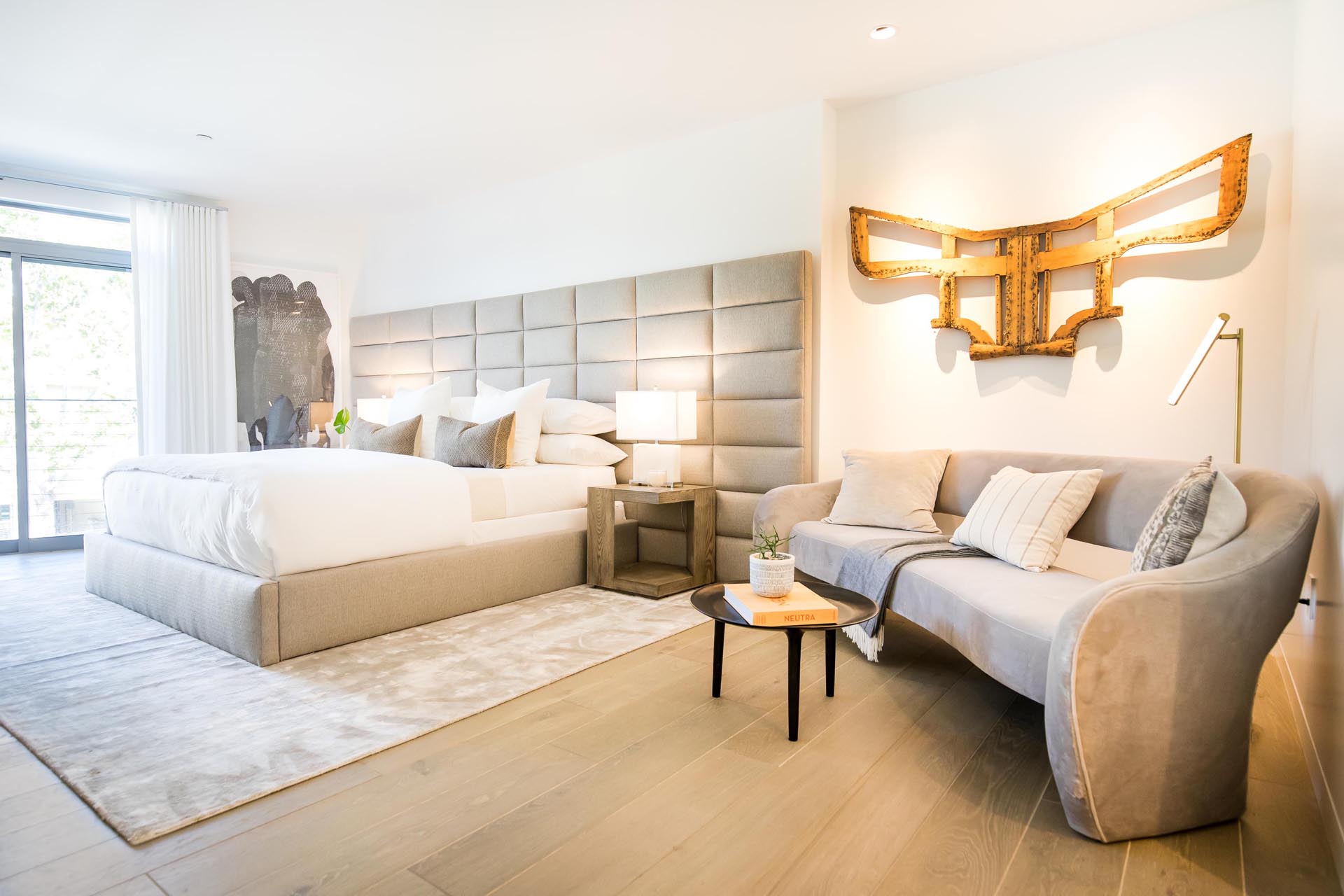 A modern bedroom with an oversized upholstered headboard.