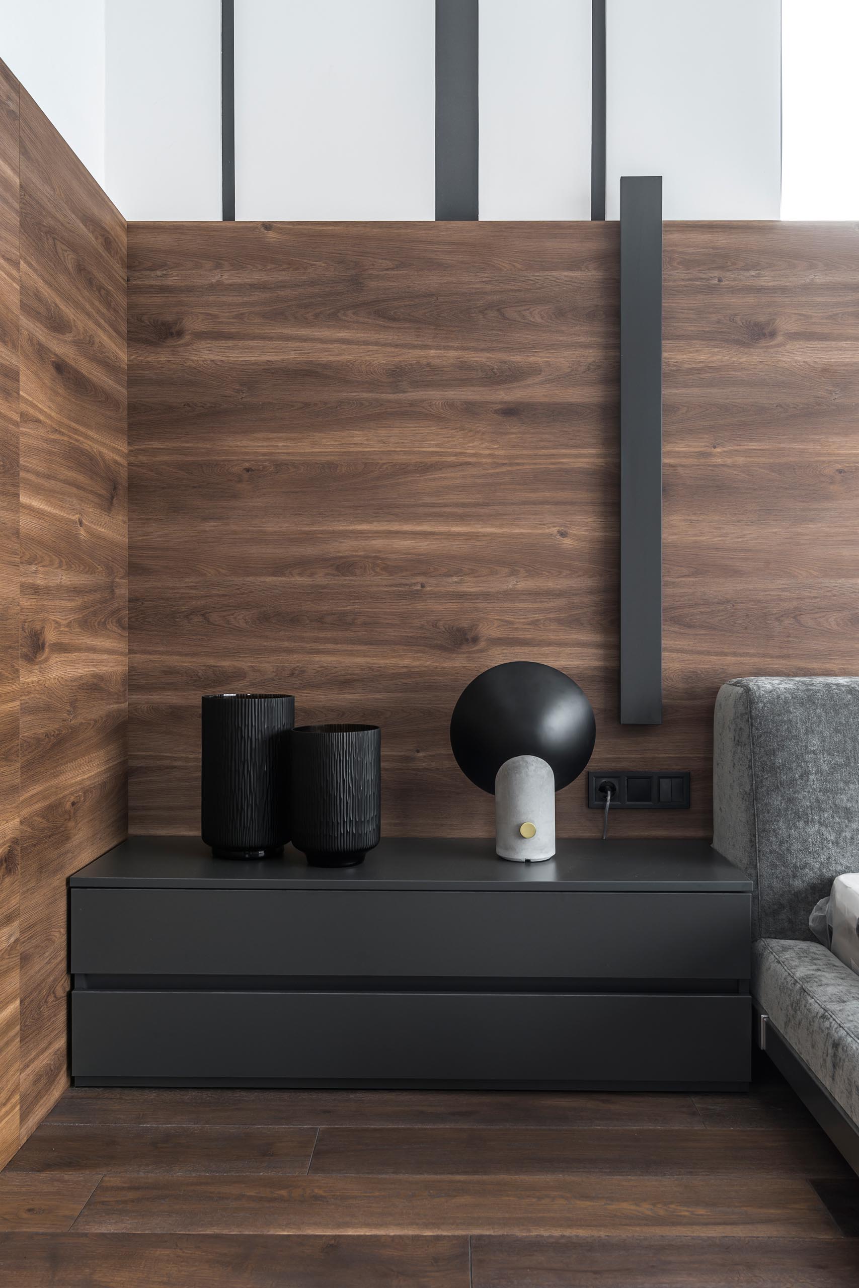 A modern bedroom with wrap around wood accent wall.