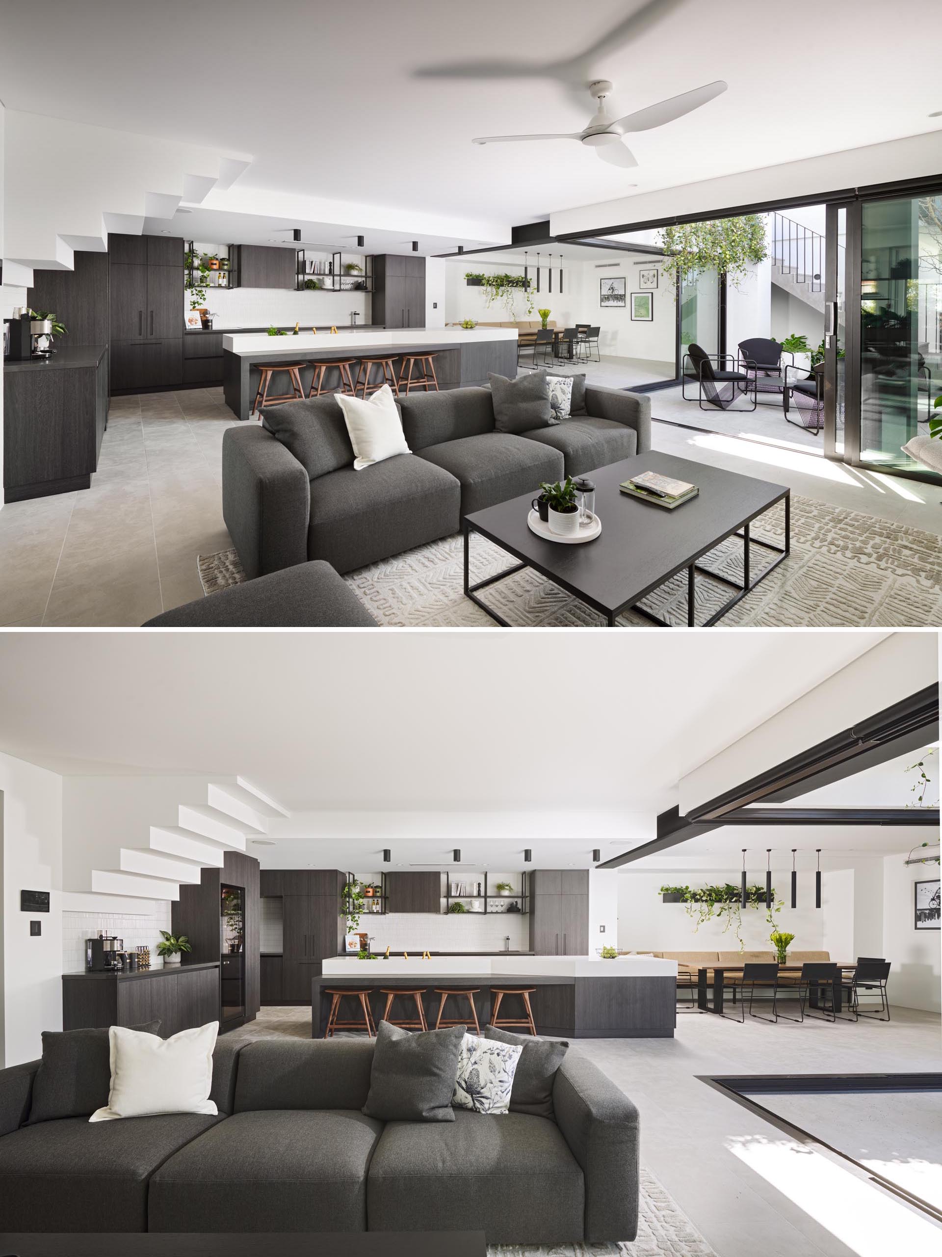 The main social areas of this modern have a color palette that includes grey tones that complement light walls and floors, and black accents.