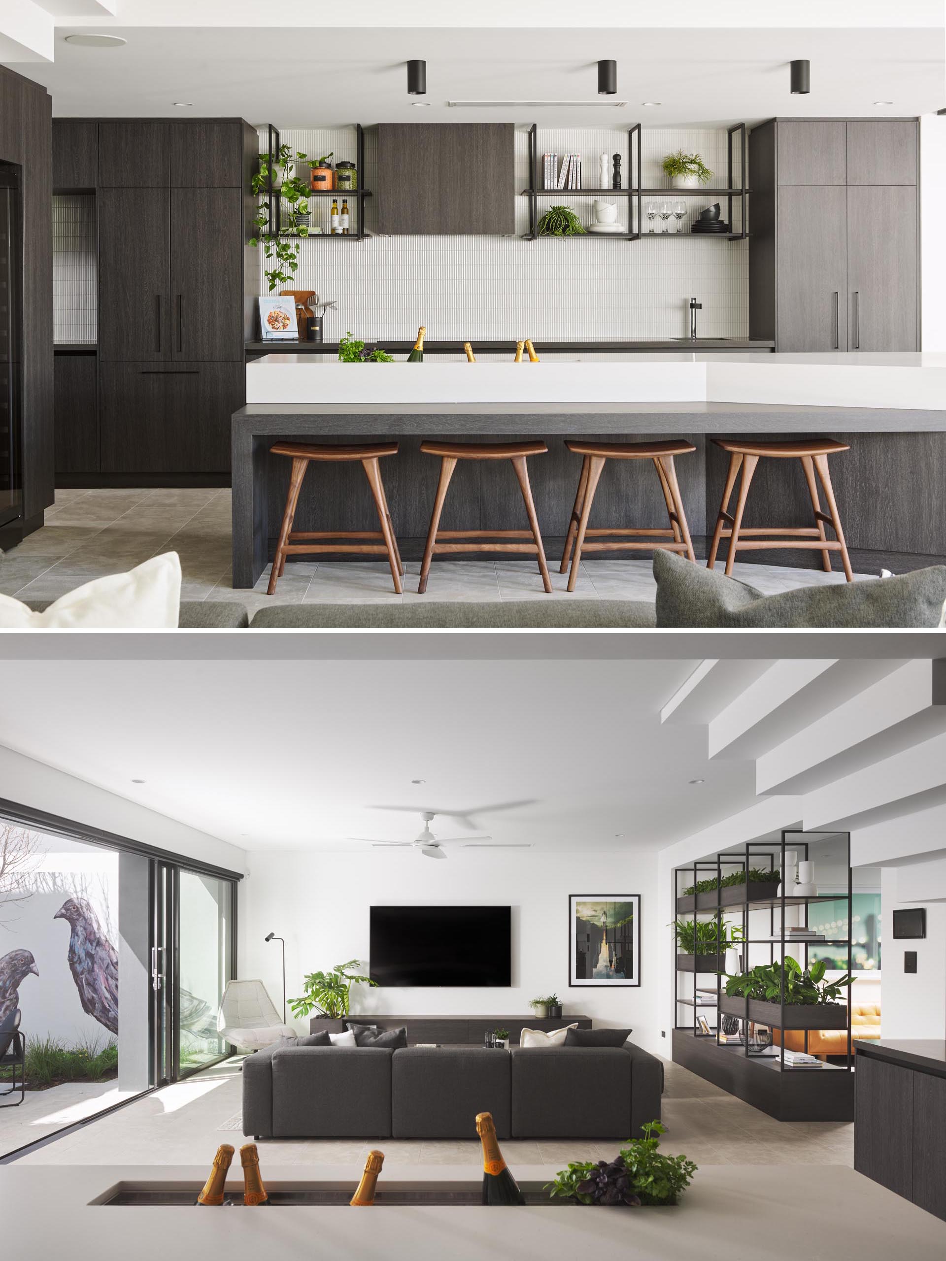 In this mdoern kitchen, dark cabinets and shelves contrast the white tile backsplash and thick white countertop of the island. There's also a drink trough built into the island, ideal for holding wine, champagne, or beer.