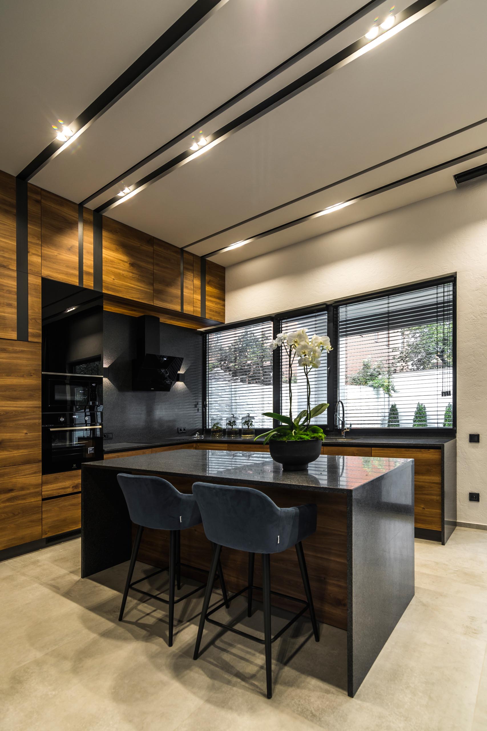 A modern gray, black, and wood kitchen with island.