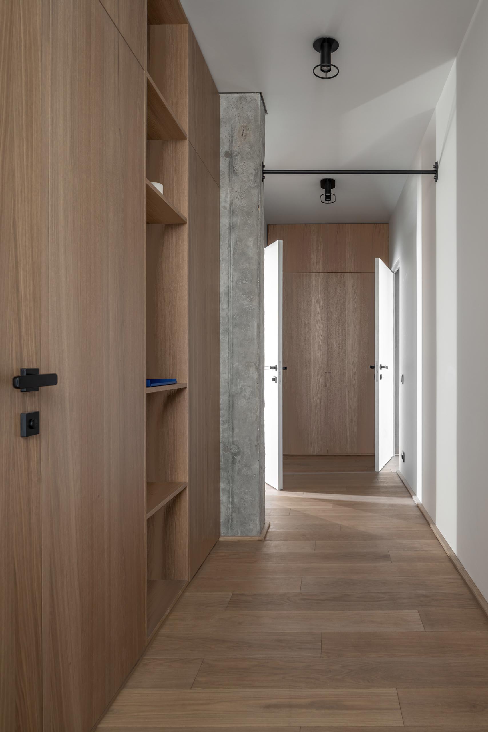 A hallway with wood cabinets provides additional storage in a modern apartment.