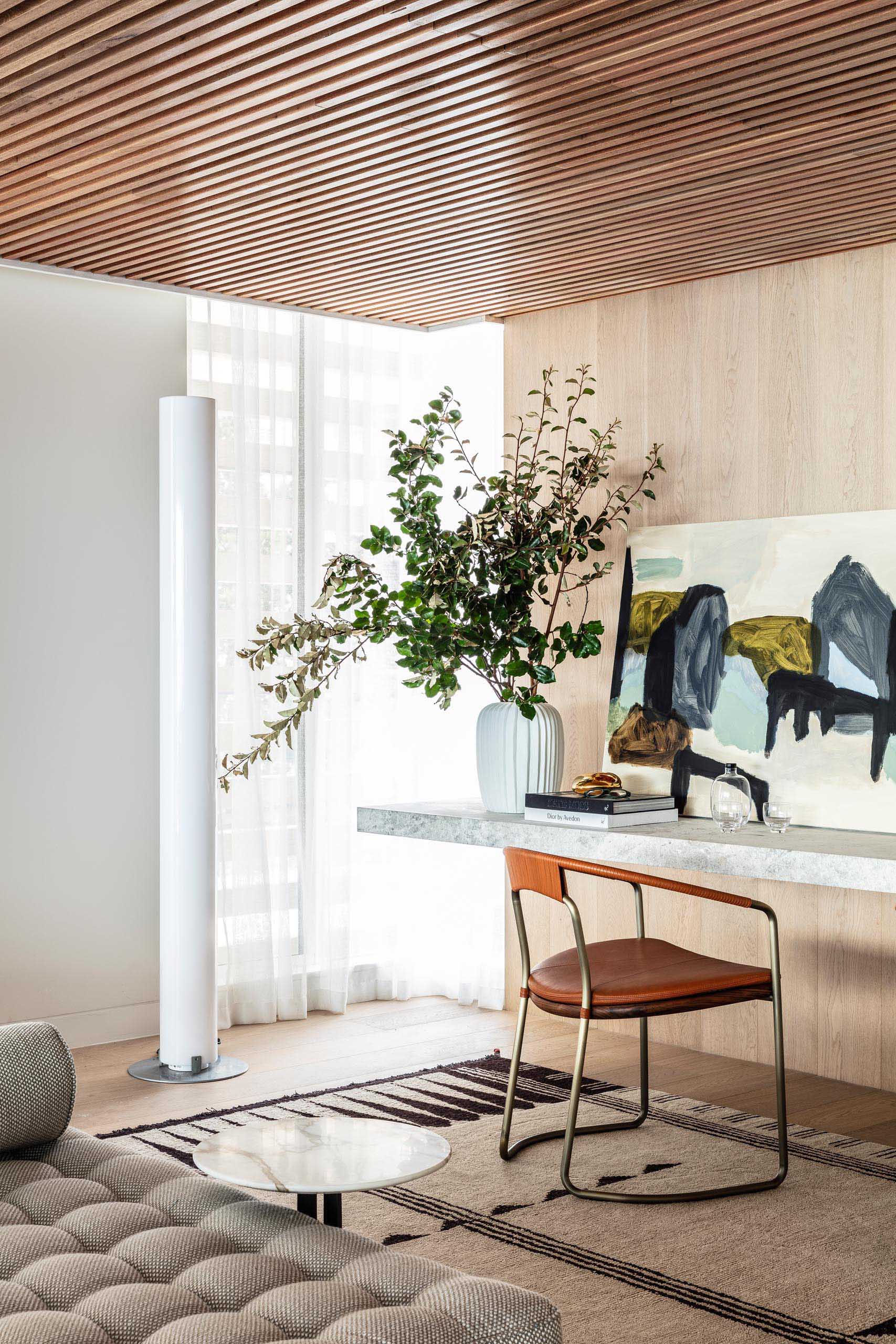 A floating stone desk lines the wall, while wood slats cover the ceiling.