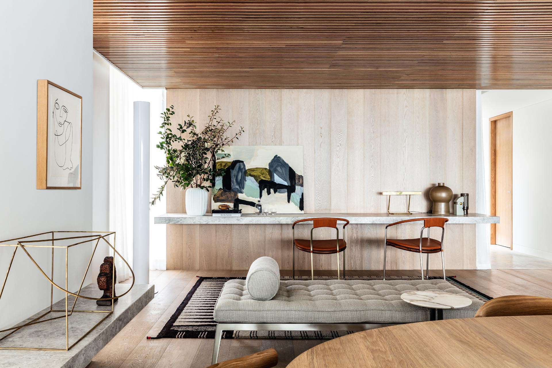 A floating stone desk lines the wall, while wood slats cover the ceiling.