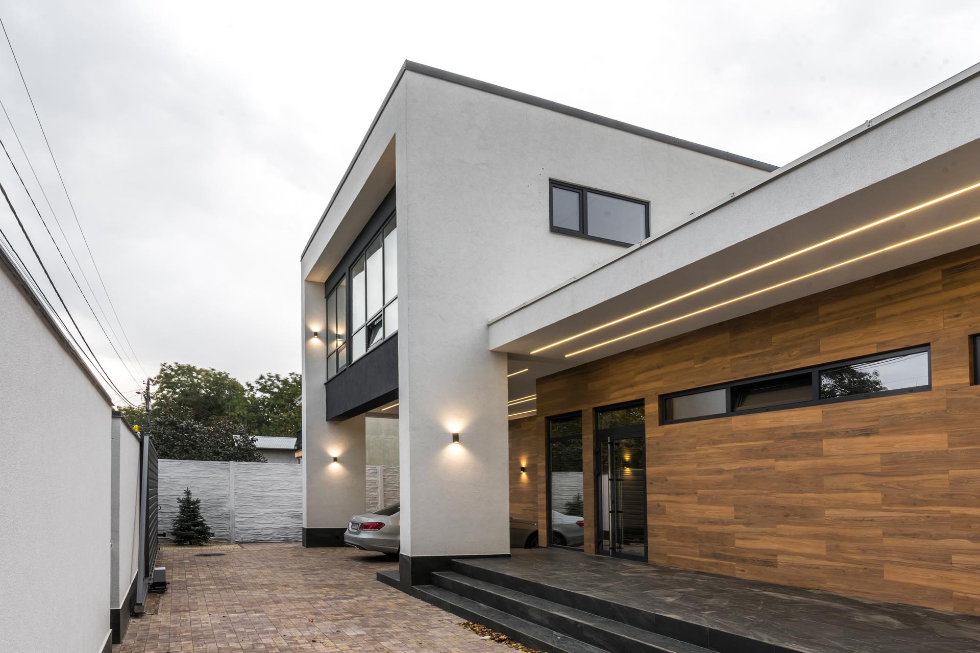 A modern home with wood-like tiles and matte black accentson the exterior.