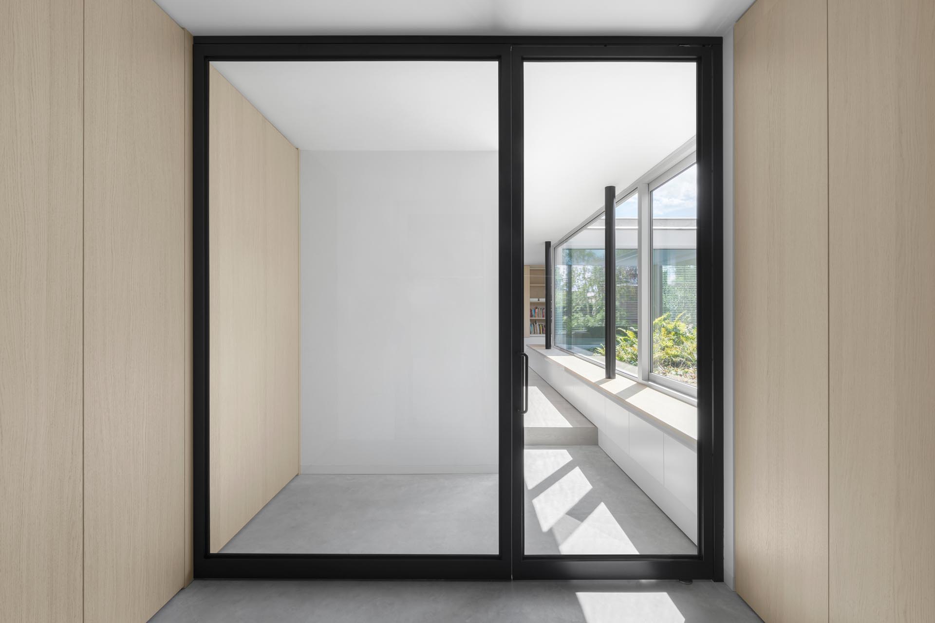 A matte black door frame and wood cabinets.