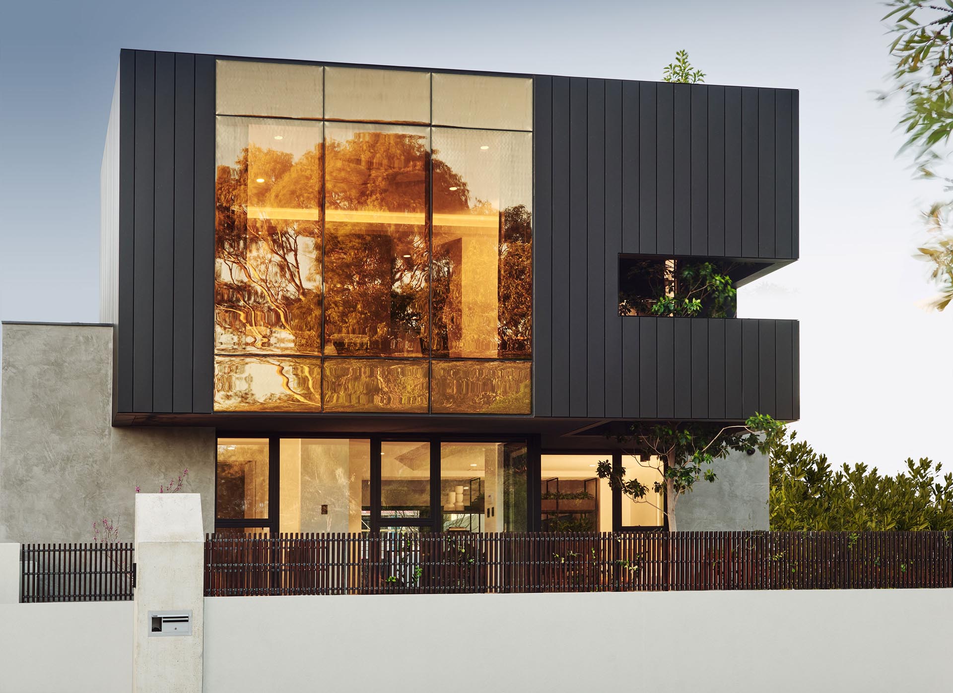 This modern home's facade features a superbronze, double glazed wall that's paired with matte siding.