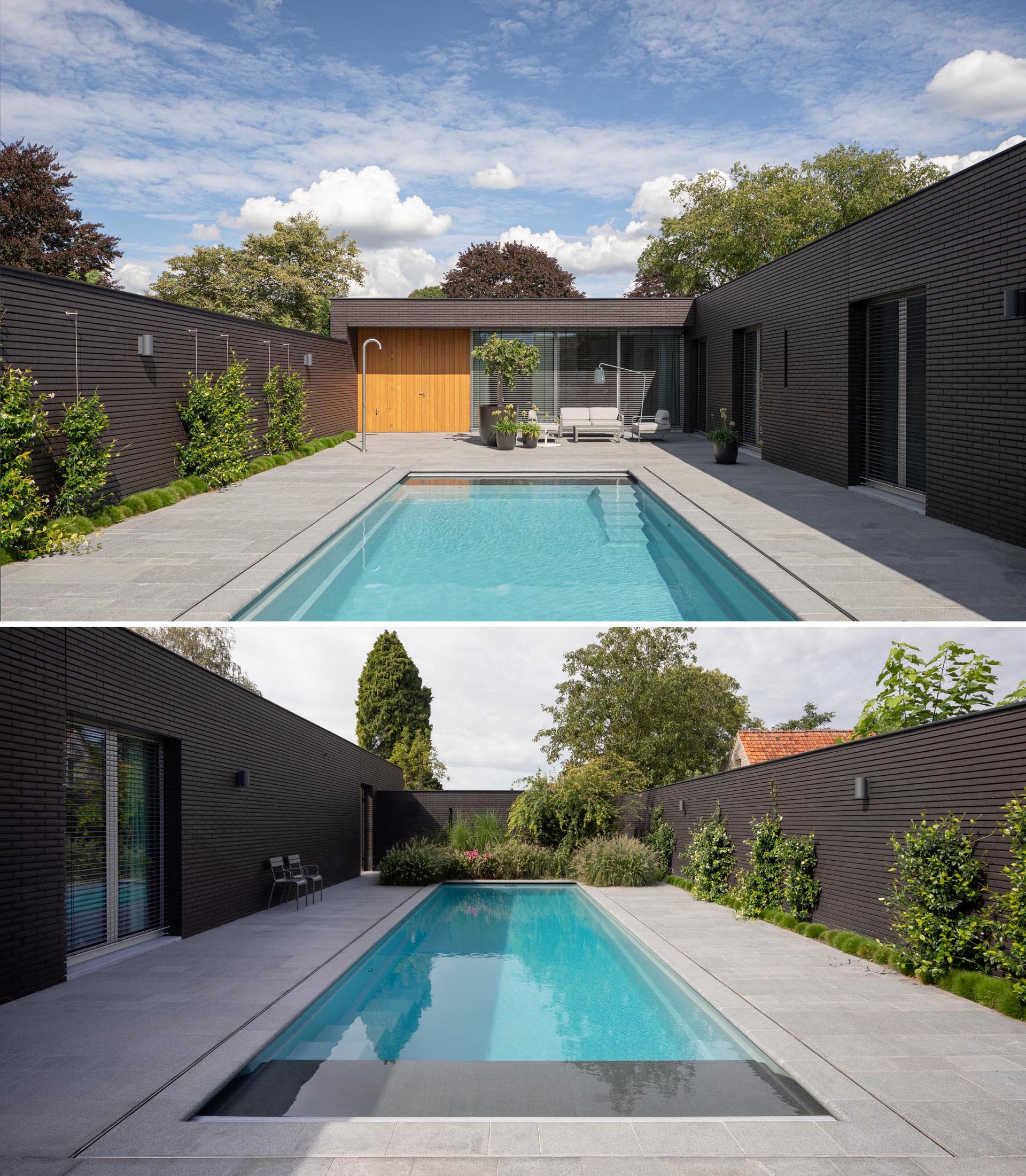 Hidden from the street is a private swimming pool with an outdoor shower and sitting area. Plants have been used as a decorative element along the walls, adding a contrasting element to the black brick.
