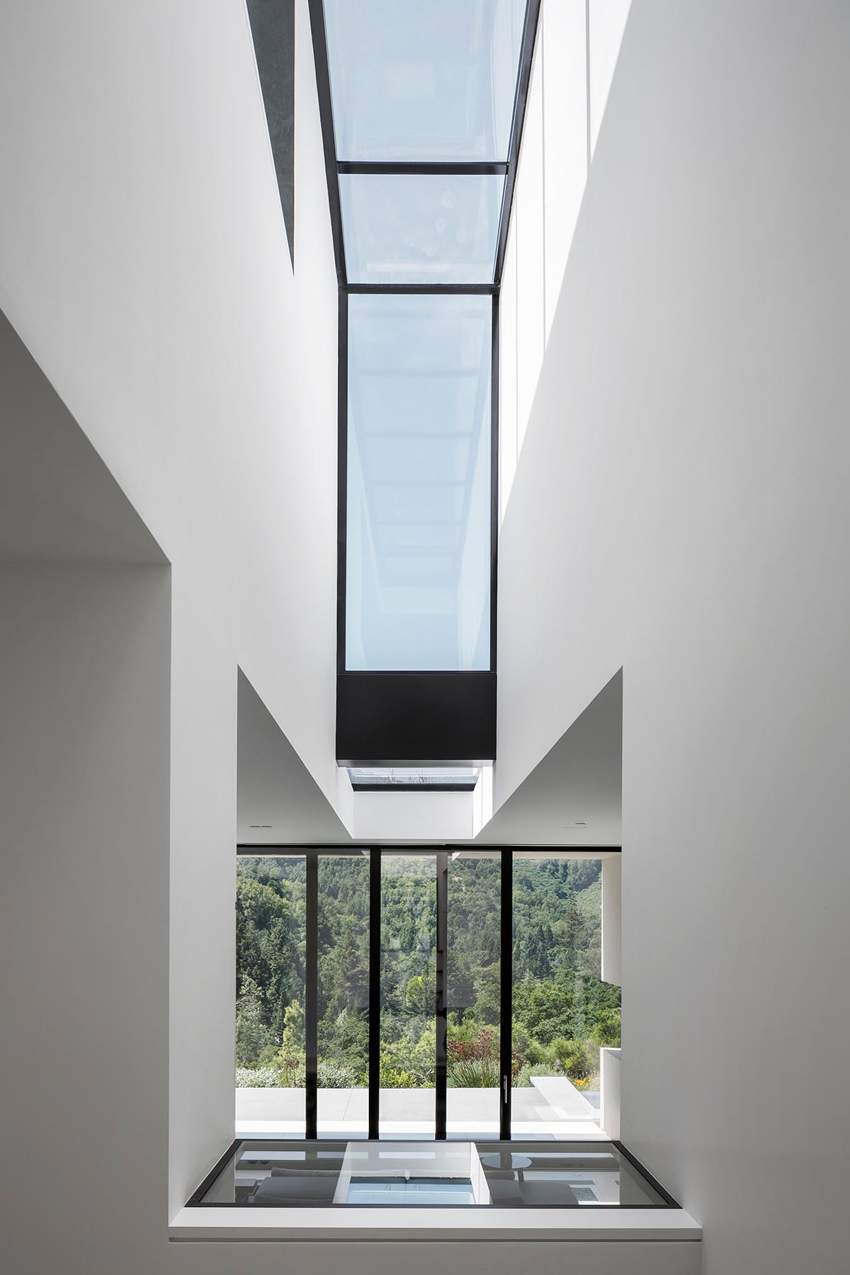 This modern house has a window that slices through a double height interior space.