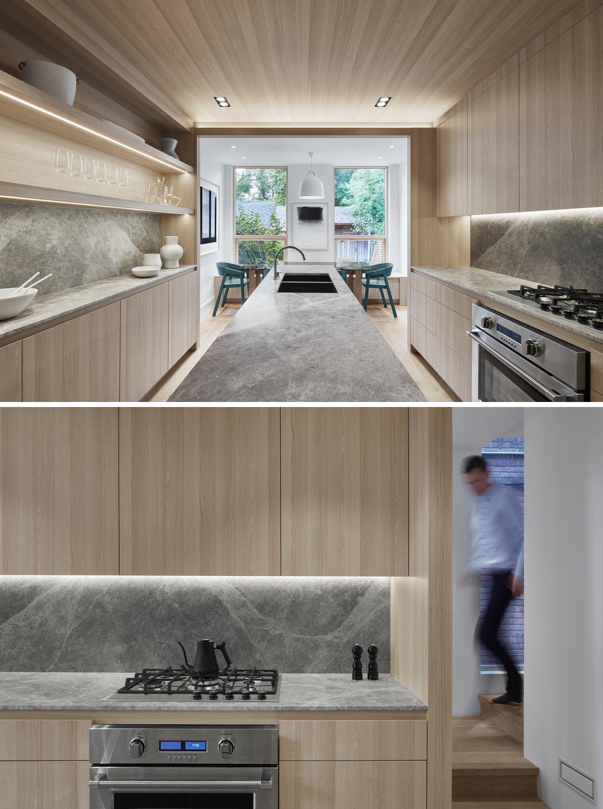 A modern kitchen with light wood cabinets, hidden lighting, and a long central island.